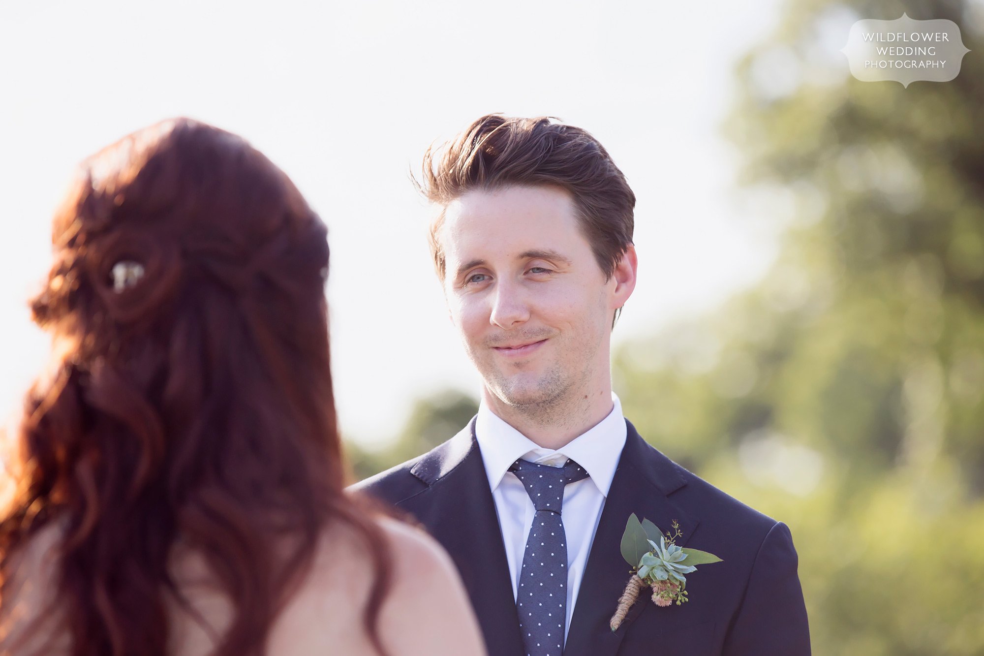 Groom looks at his bride during their summer outdoor wedding at Les Bourgeois in Rocheport, MO.