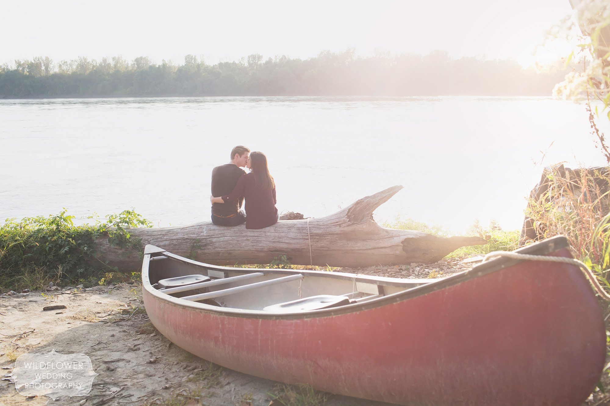 Couple kissing with the Missouri River in the background at Cooper's Landing during their engagement photo session.