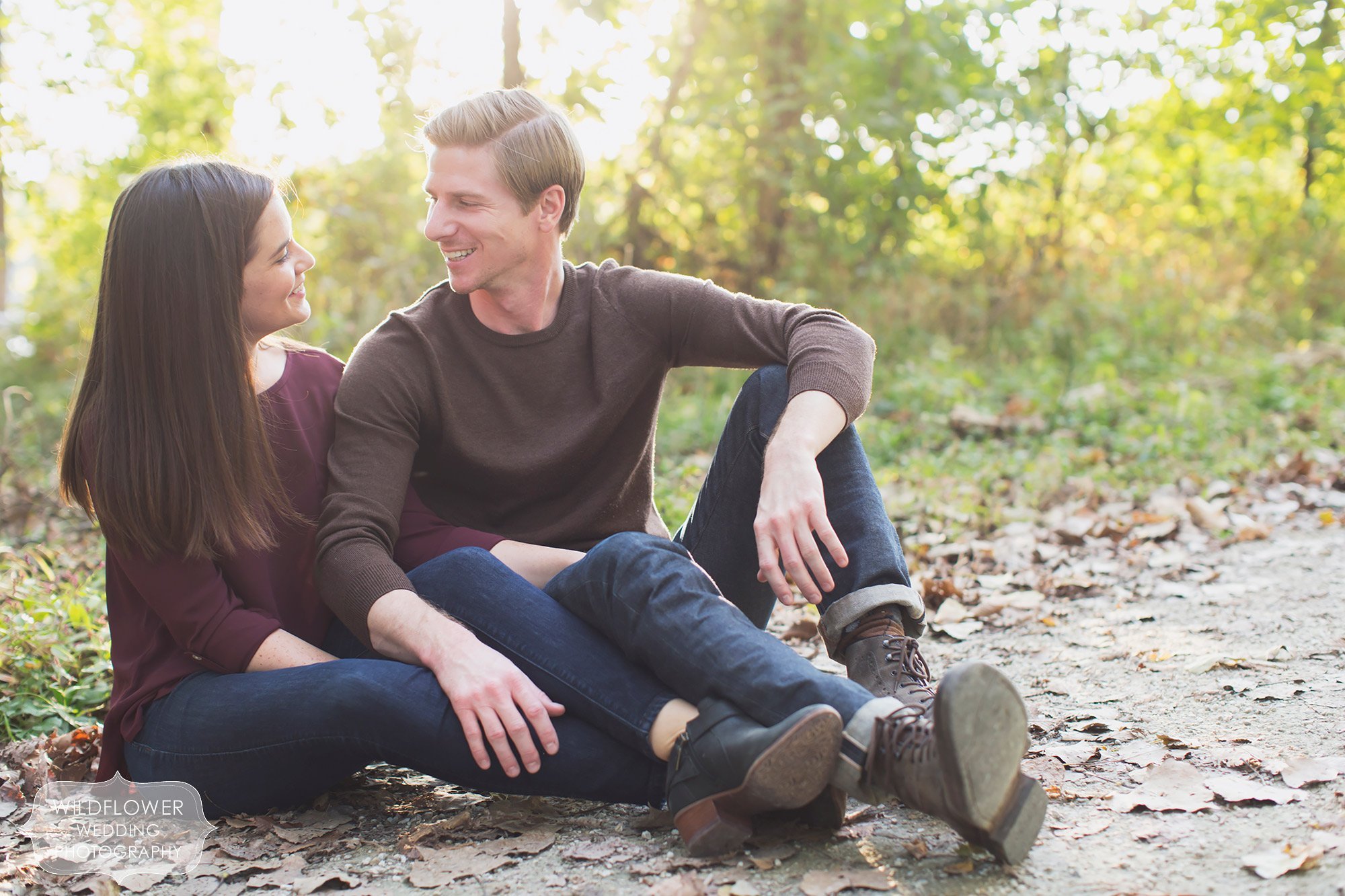 Couple sits on the ground along the Katy Trail near Cooper's Landing during their October engagement session.