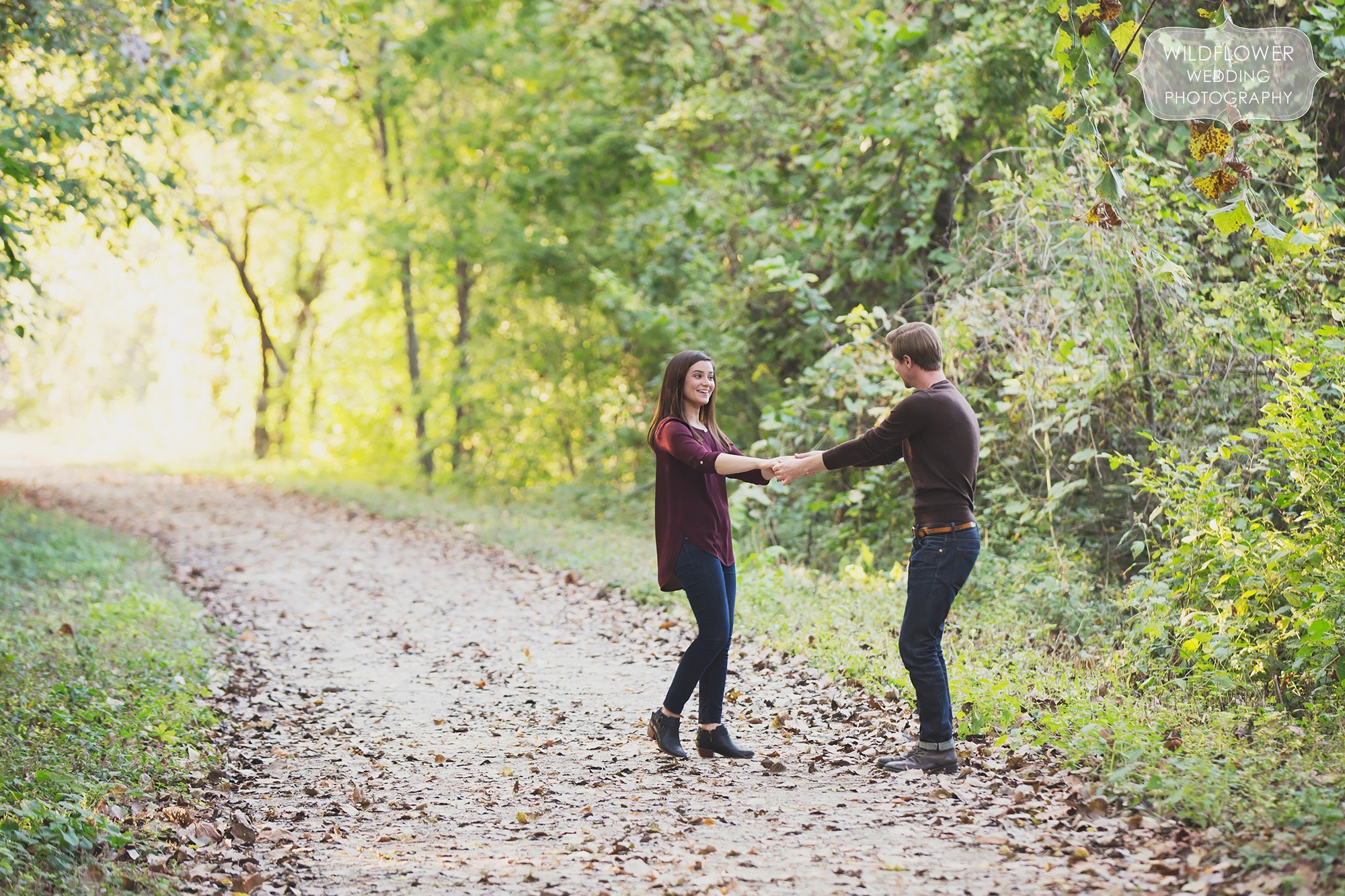 A couple dances on the Katy Trail near Cooper's Landing during their woodsy engagement photography session.