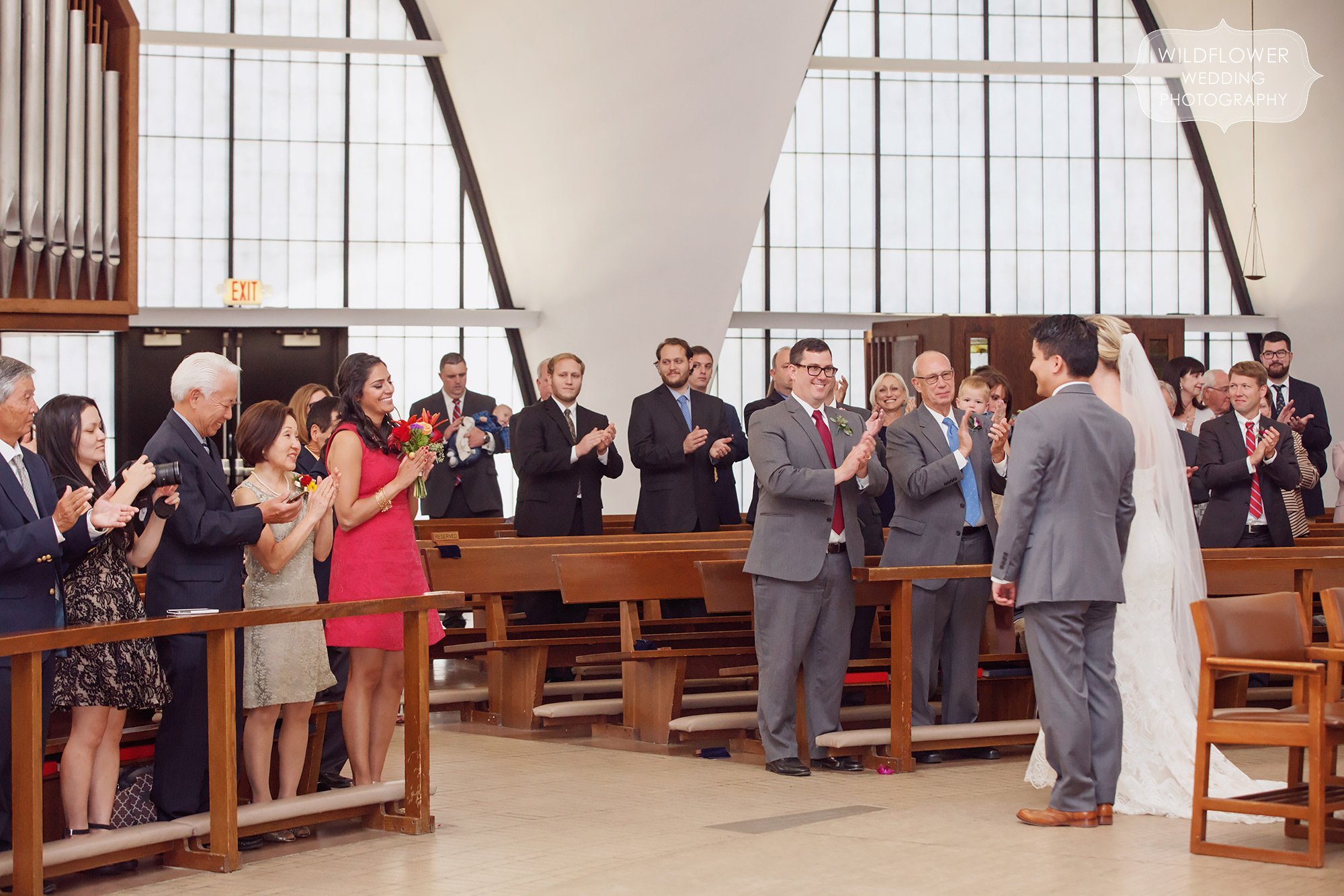 Wedding guests clap during this Priory School ceremony.