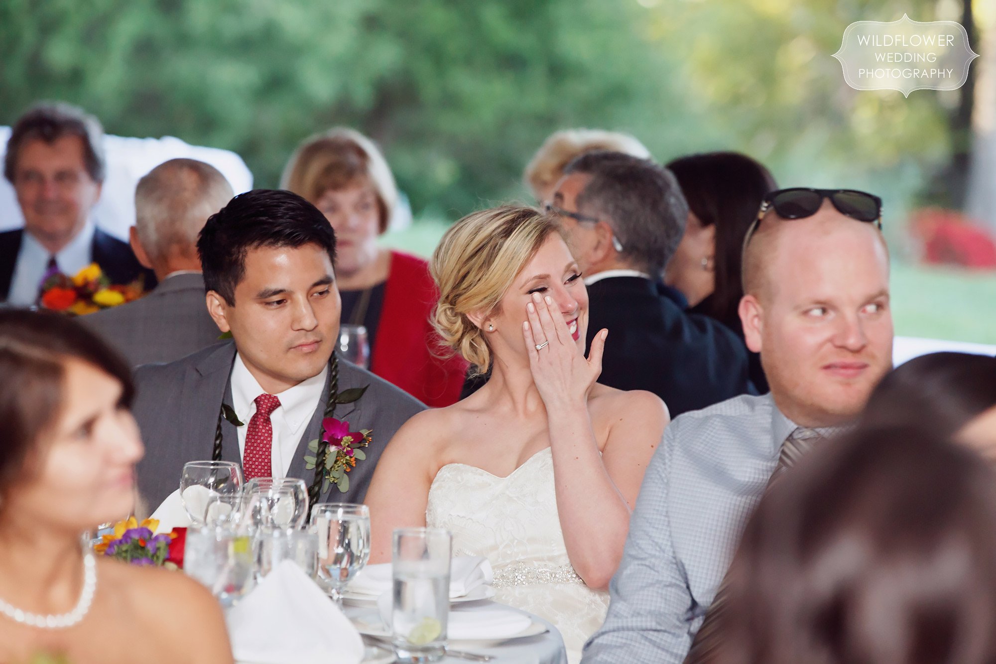 Emotional photo of the bride wiping away tears during her dad's speech at this backyard wedding in St. Louis.