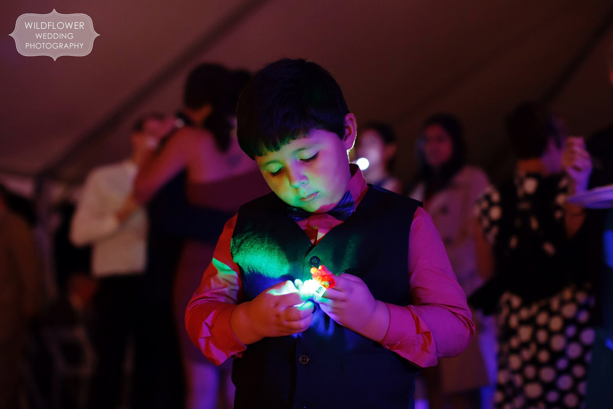 Unique photo of a little boy with a glow ring at this backyard wedding reception in St. Louis.
