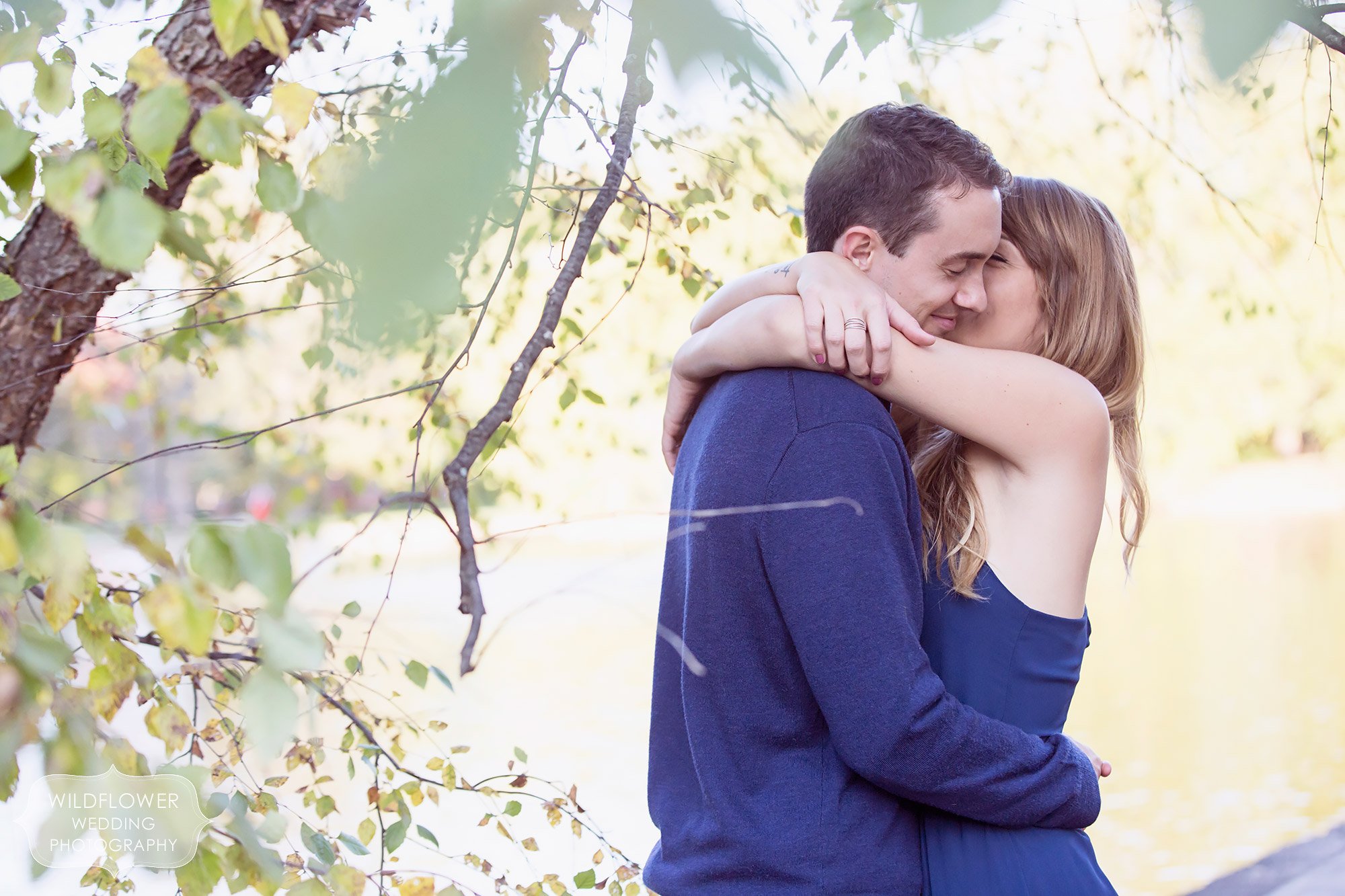 Romantic engagement photo of the girl wrapping her arms around her fiance at Loose Park in Kansas City, MO.