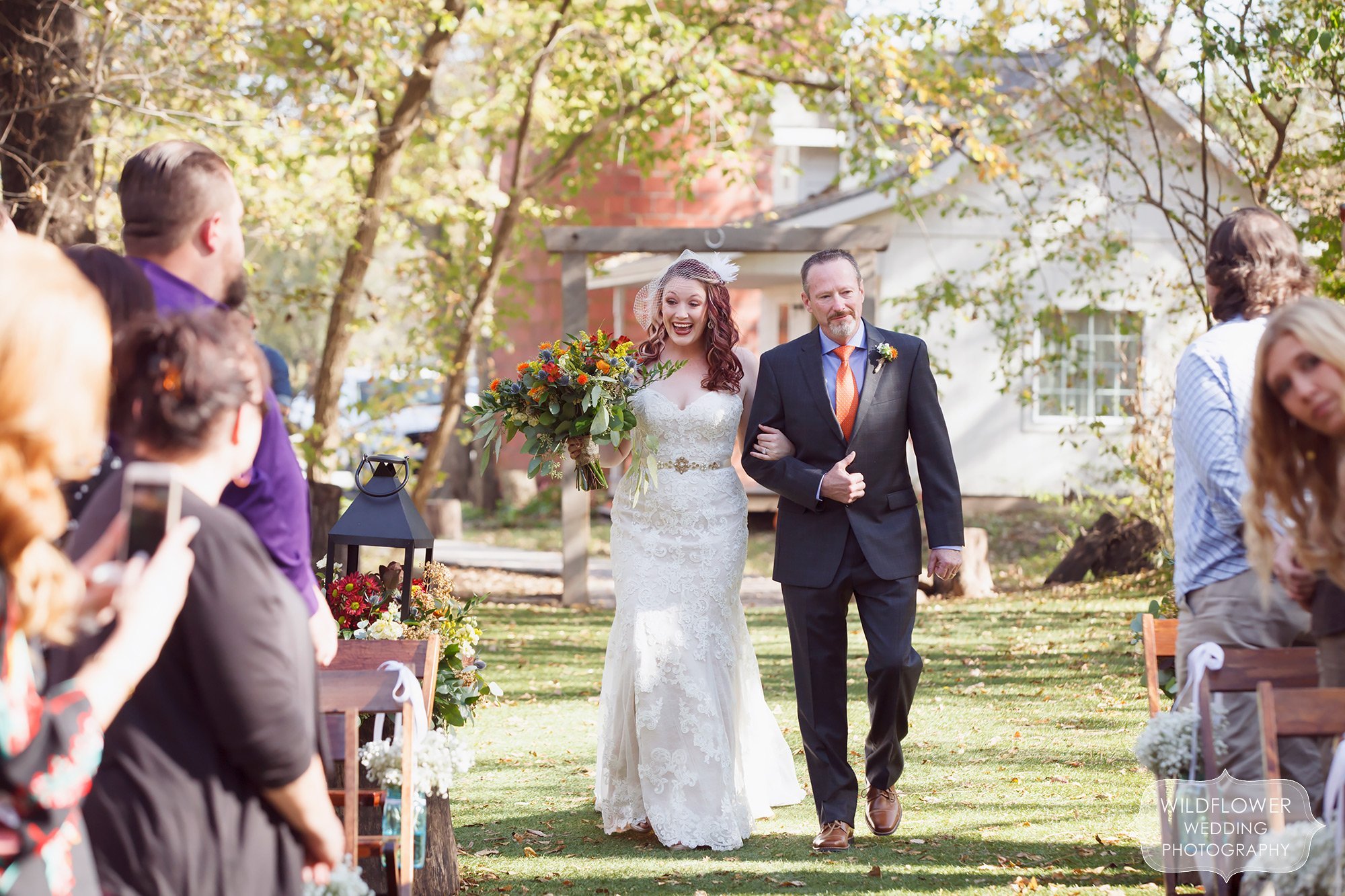 Happy photo of the bride and her father walking down the aisle before the Schwinn Produce Farm ceremony in October.