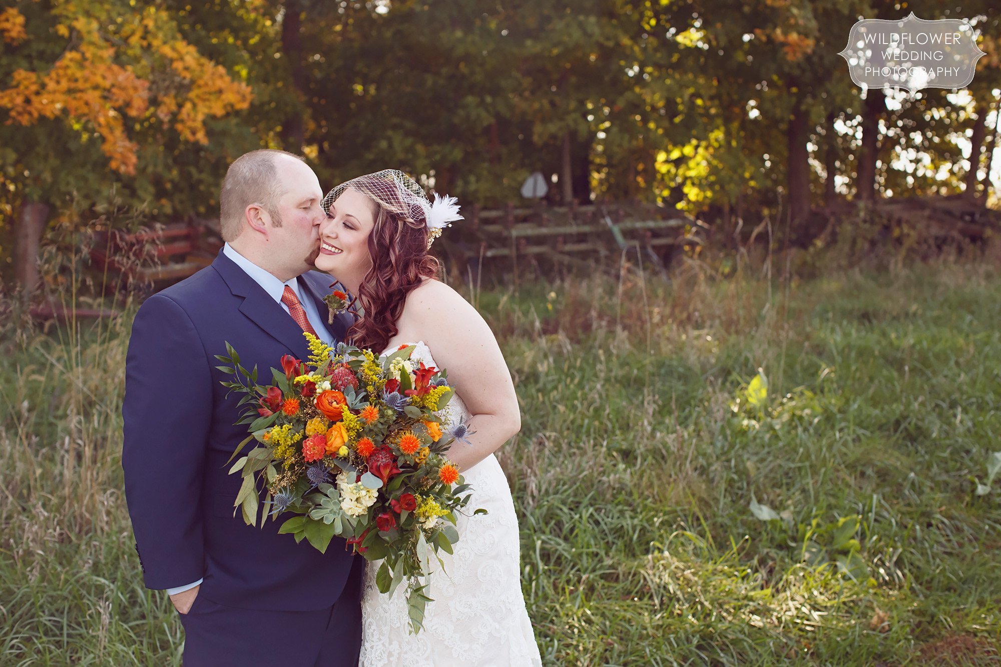 Sweet photo of the groom kissing the bride's cheek at this rustic Kansas barn wedding.
