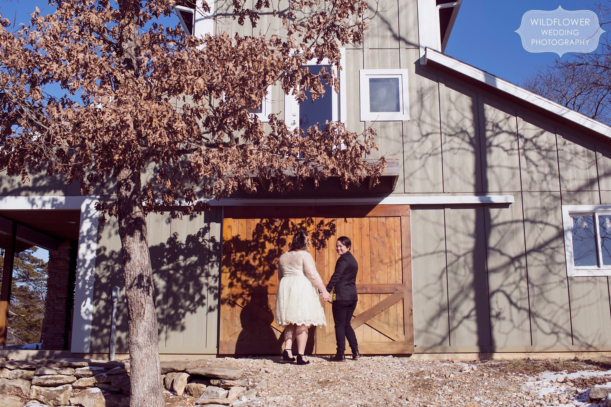 Two women wait outside of the barn for their grand entrance of their same sex winter wedding in Columbia, MO.