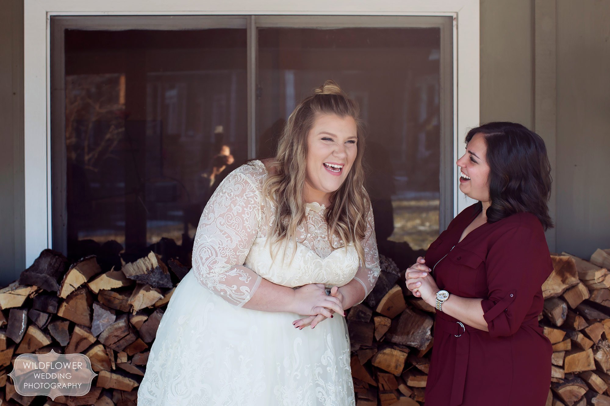 Great documentary photo of the bride laughing with her best friend after her same sex ceremony in the winter.