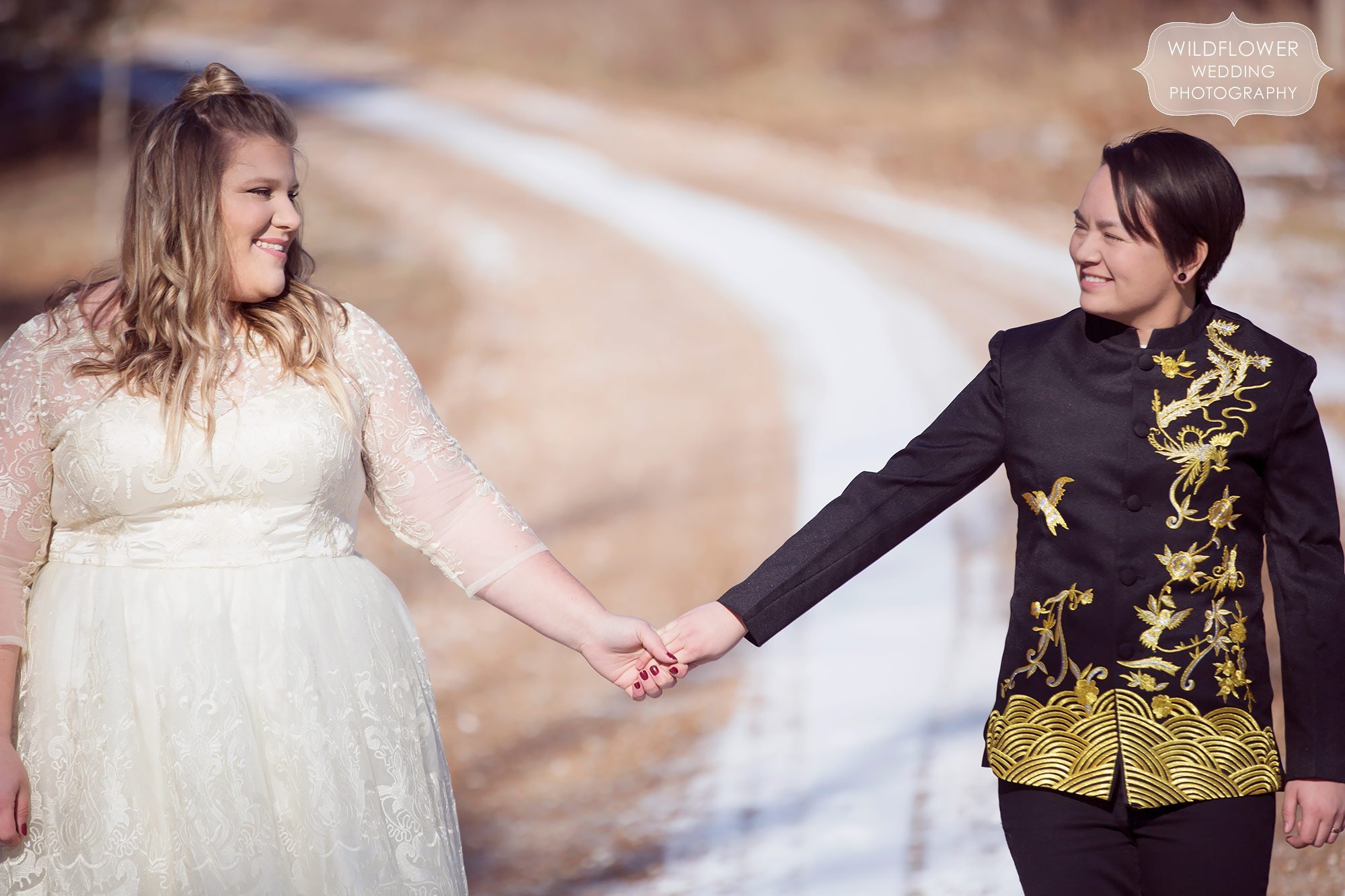 A queer couple poses on a snowy road before their same sex wedding ceremony in Columbia.