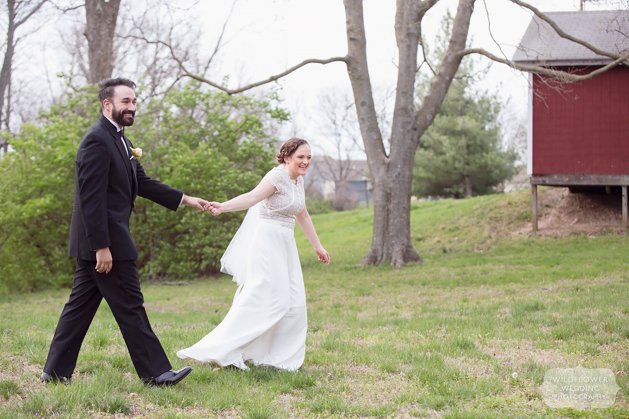 Candid photo of the bride pulling the groom along before their elopement ceremony near the Maplewood Barn.