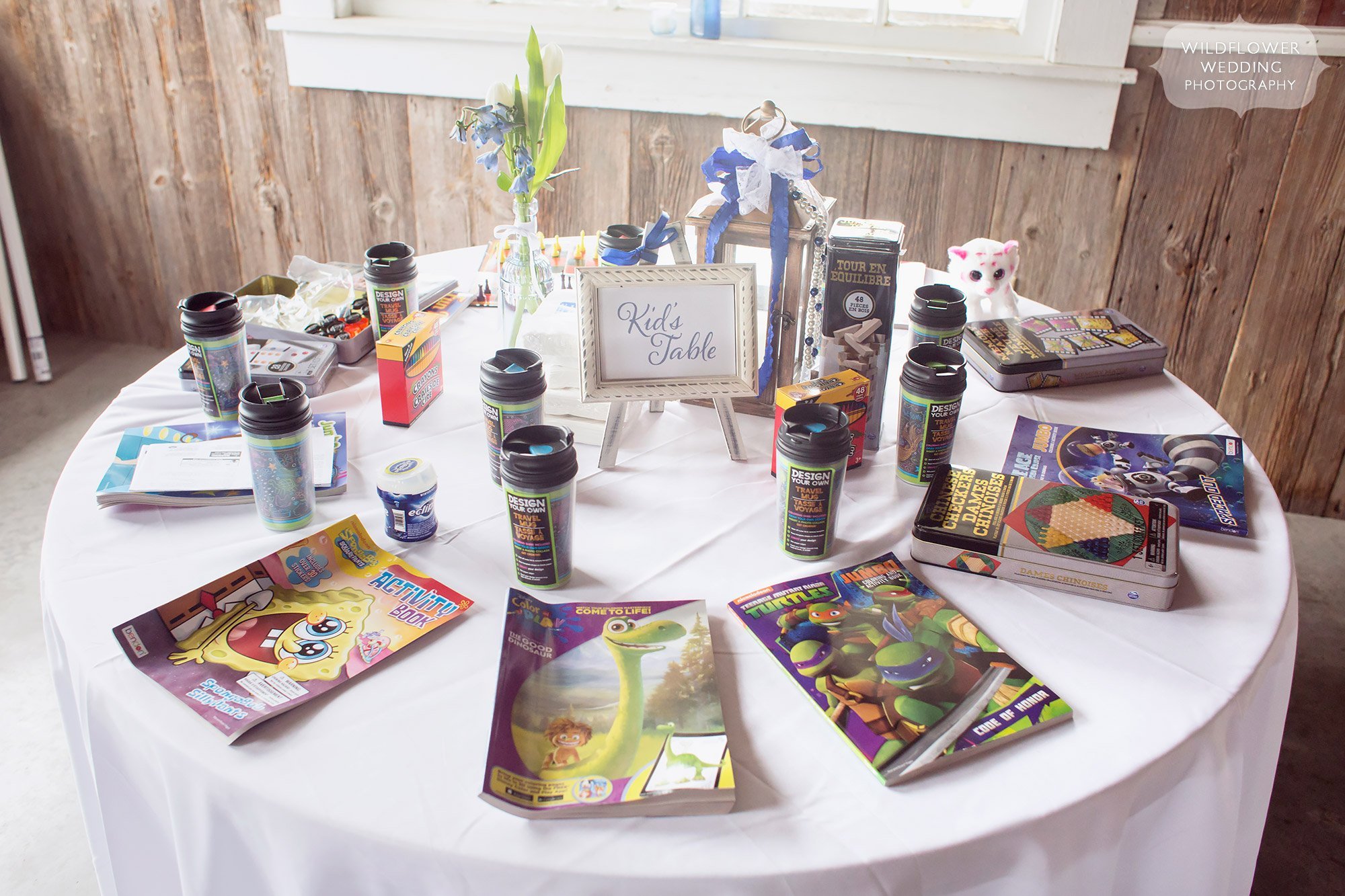 Great idea for a kids table set up with coloring books and sippy cups at this Weston, MO farm wedding.
