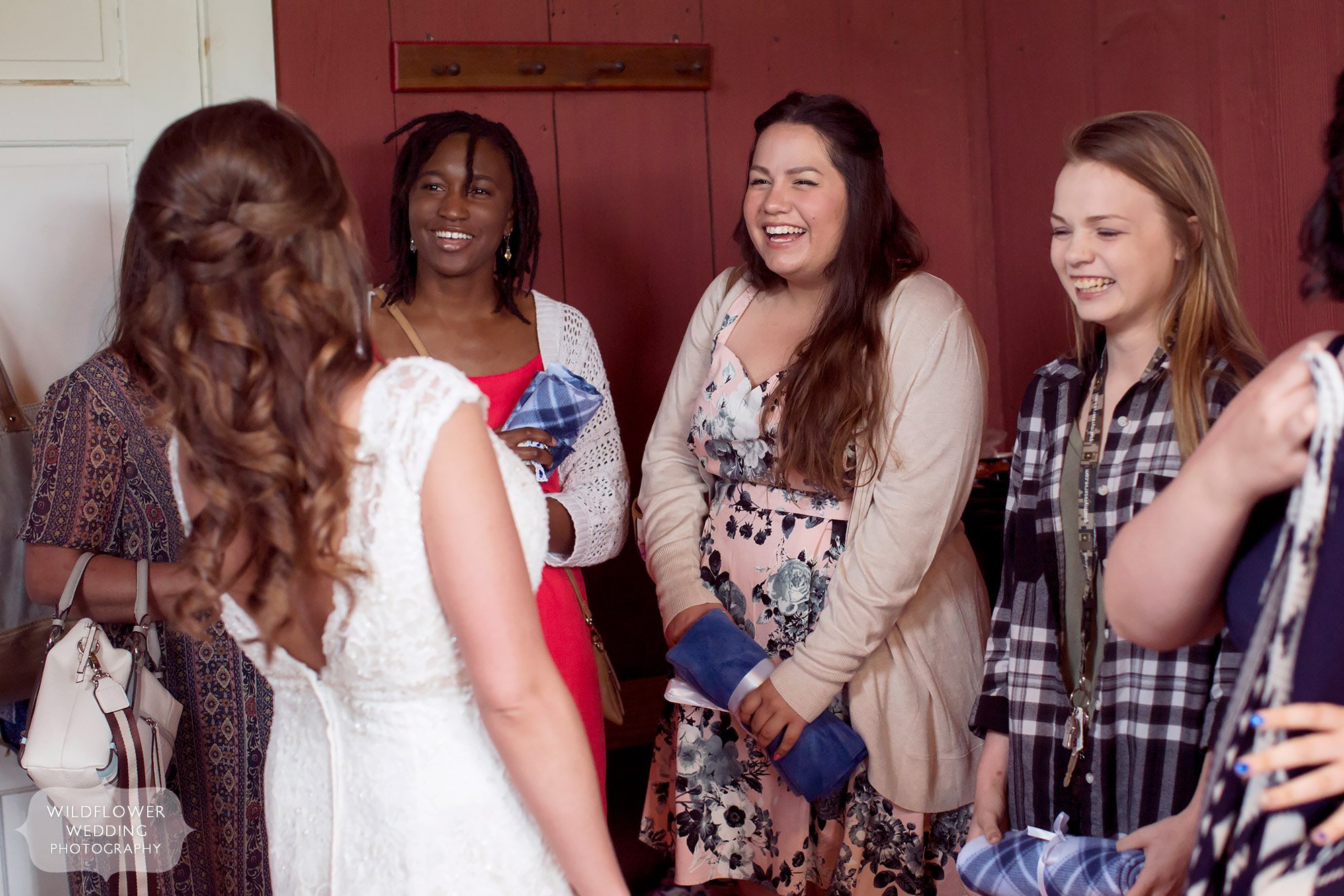 Great documentary photo of the bride's friends seeing her for the first time at the Weston Red Barn Farm.