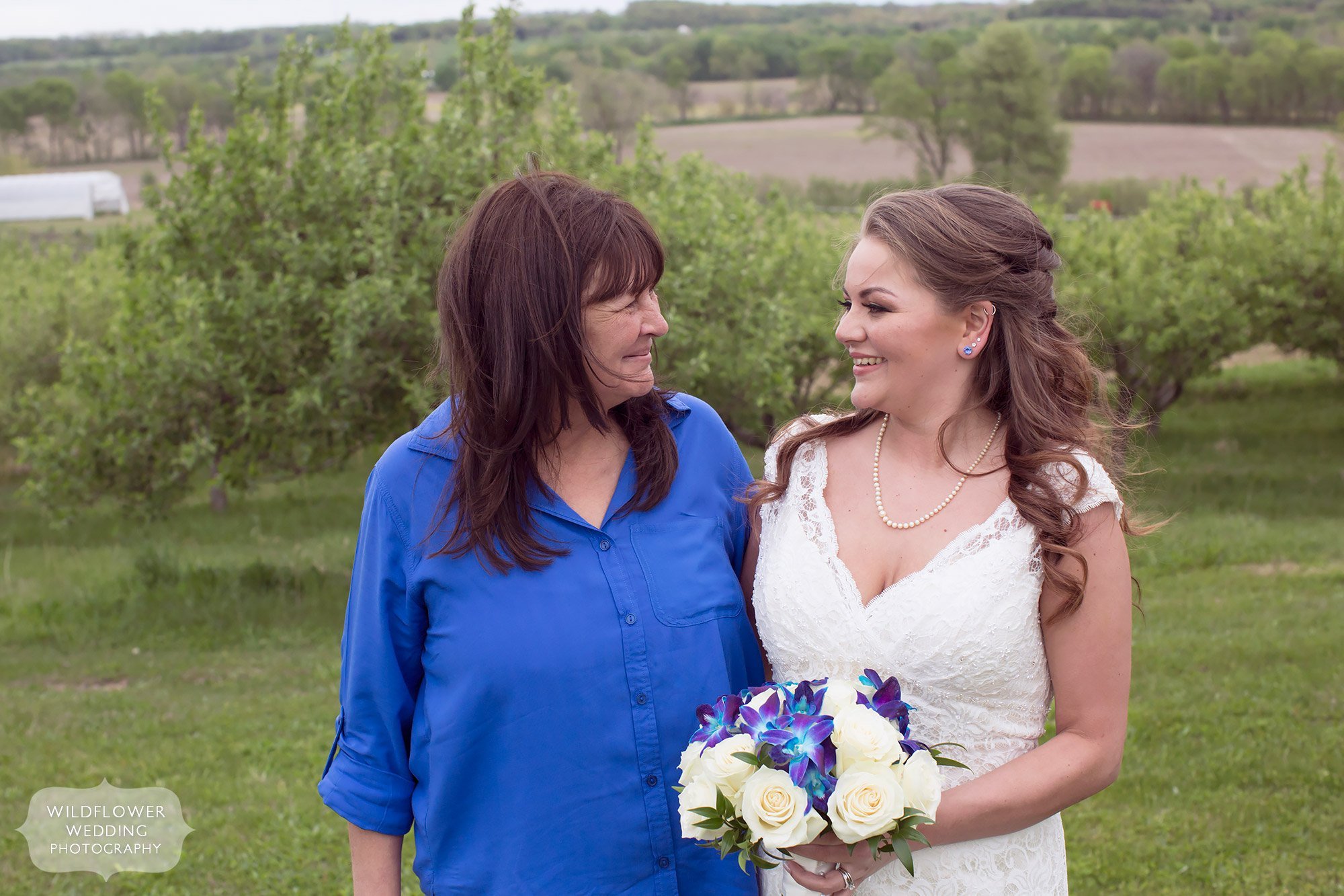 Sweet photo of the bride and her mom in the orchard at this farm wedding in MO.