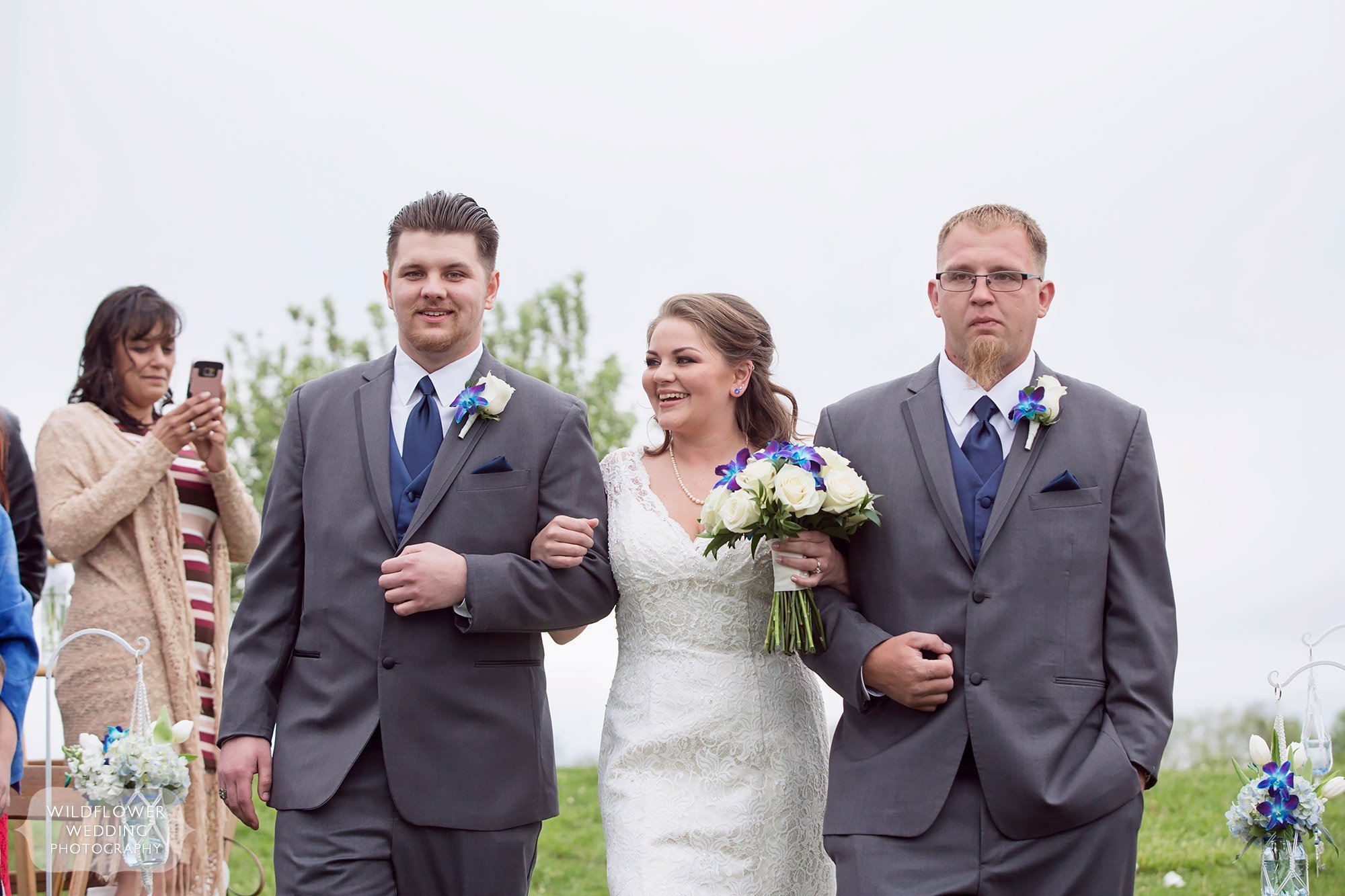 Bride is walked down the aisle by her brothers at this farm wedding in KC.