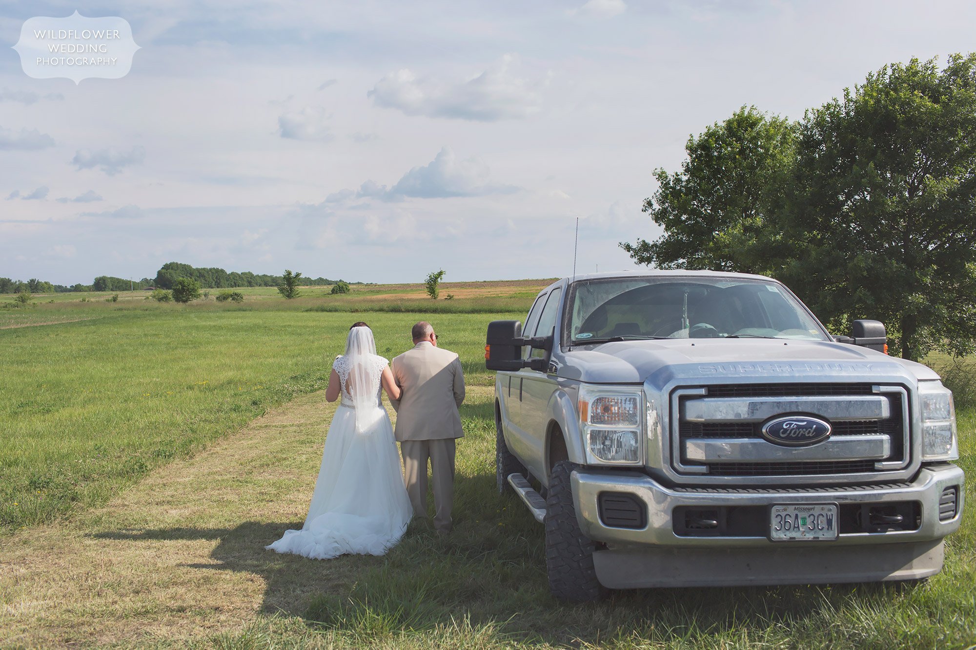 The bride and her dad stand next to his Ford truck before walking down the aisle at their outdoor country wedding in Columbia, MO.