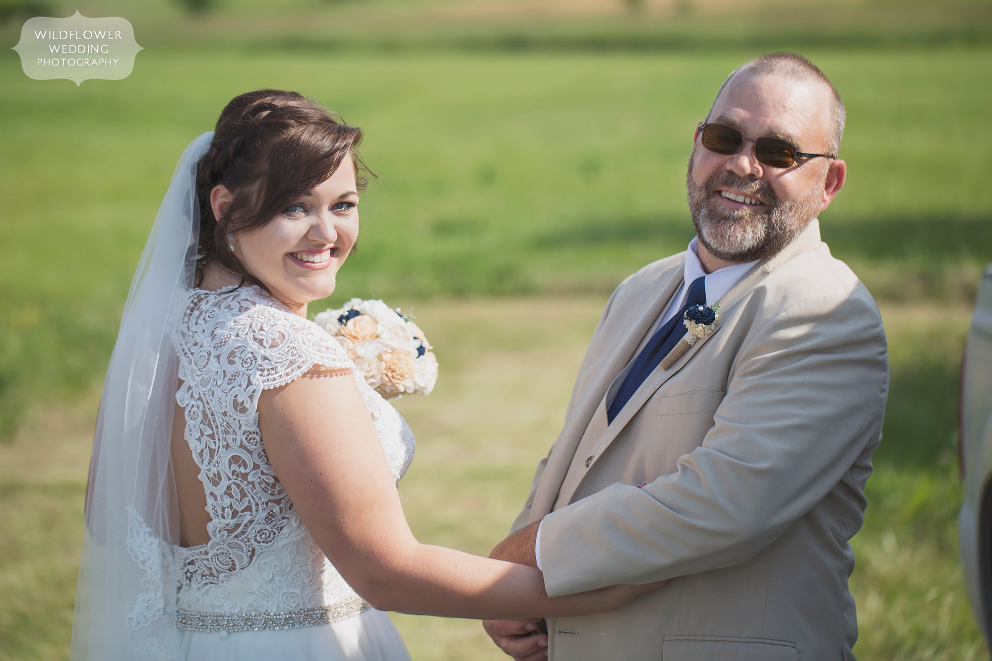 Father and daughter hold hands before the ceremony in the country in mid-MO.