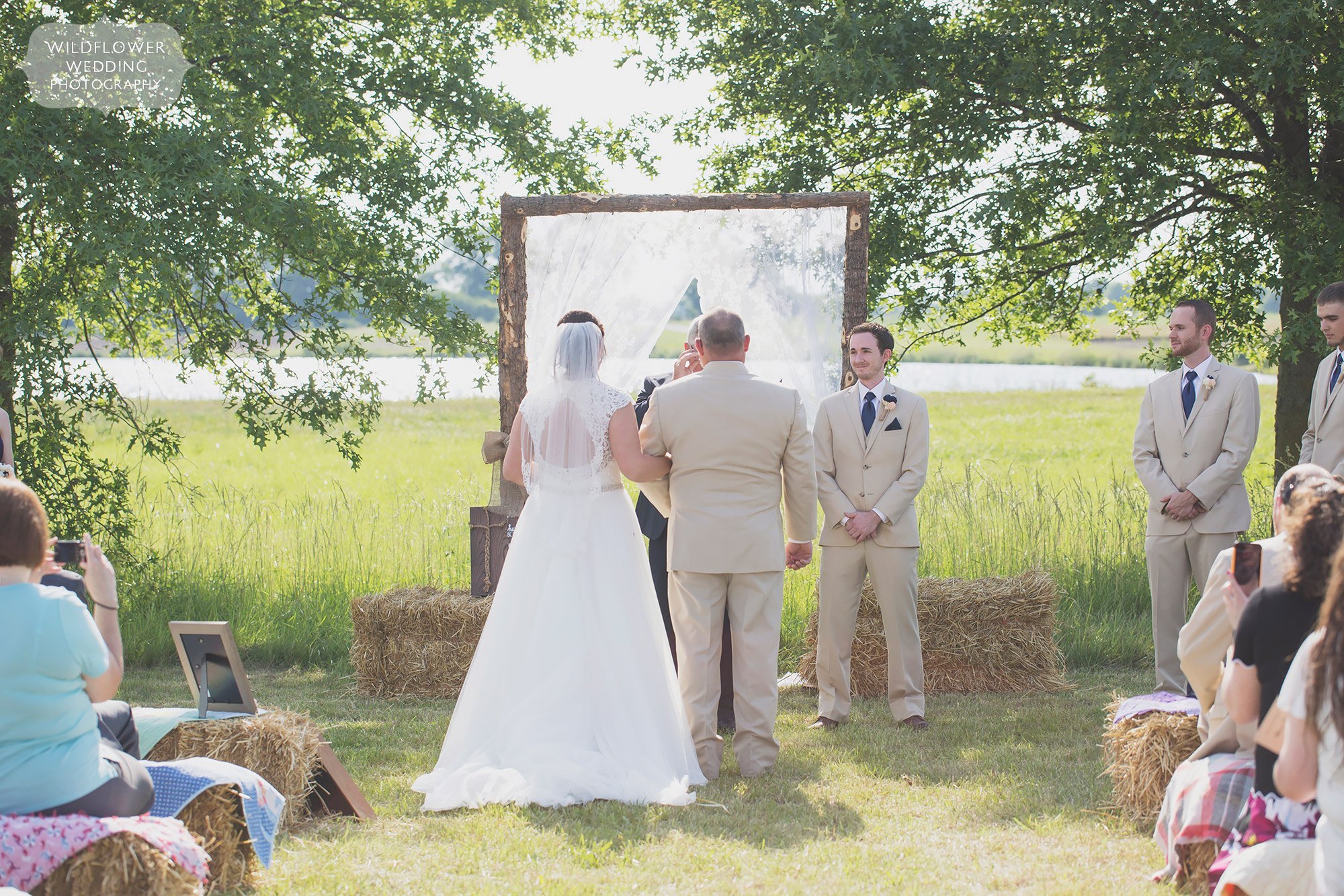 This rustic and country outdoor wedding ceremony in a field at the Bradford Farm is beautiful.