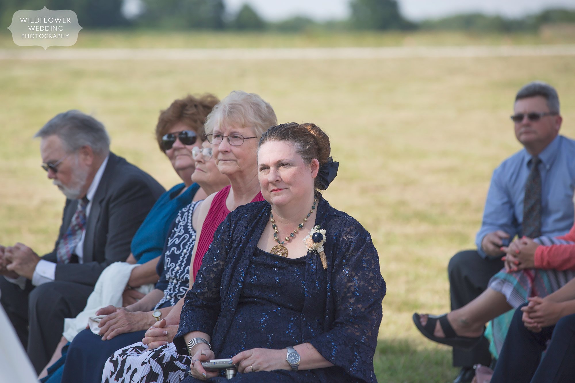 Mother of groom watches her son tie the knot during their outdoor ceremony in Columbia, MO.