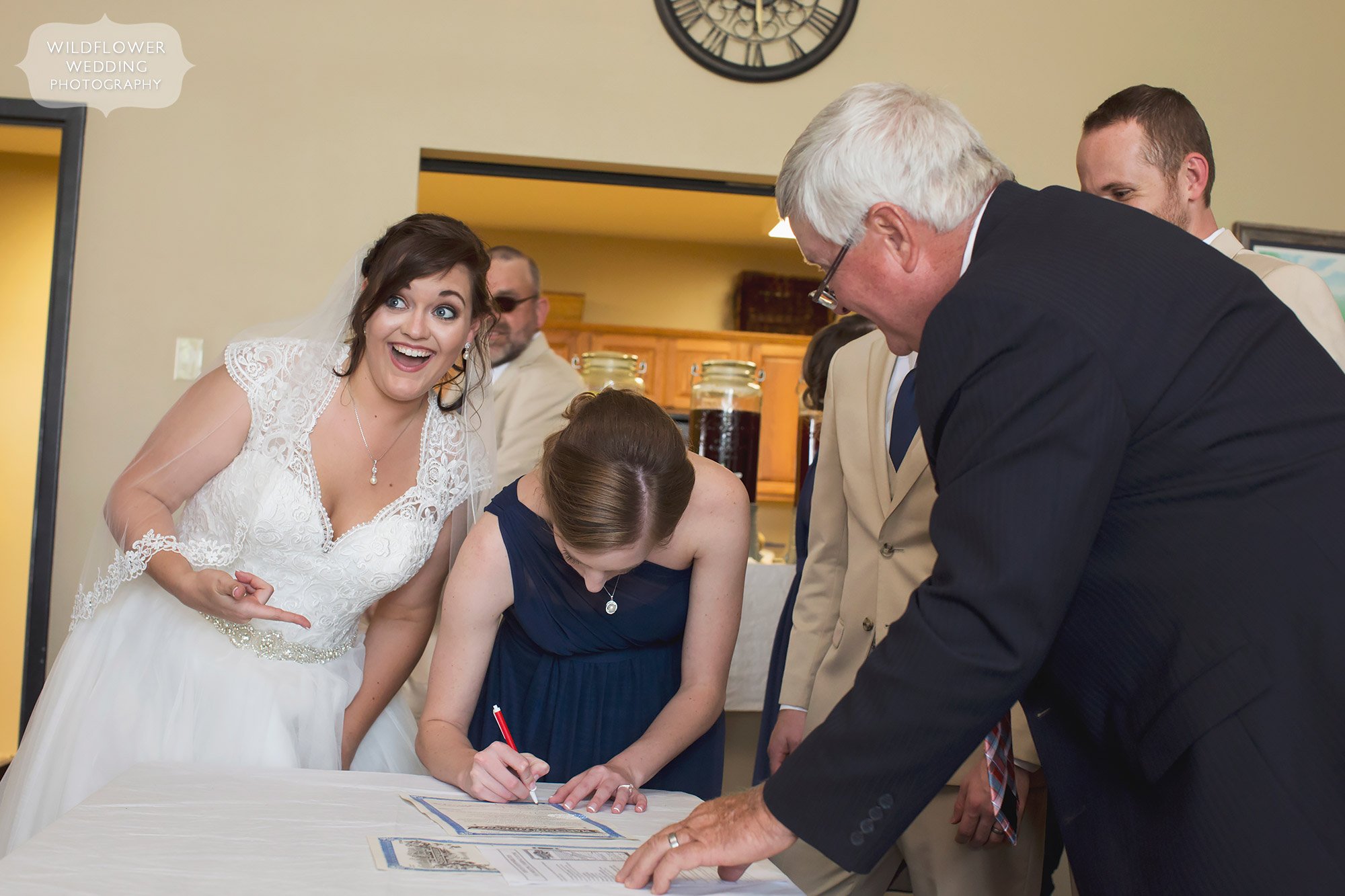 Candid wedding photo of the bride signing wedding certificate after country wedding.