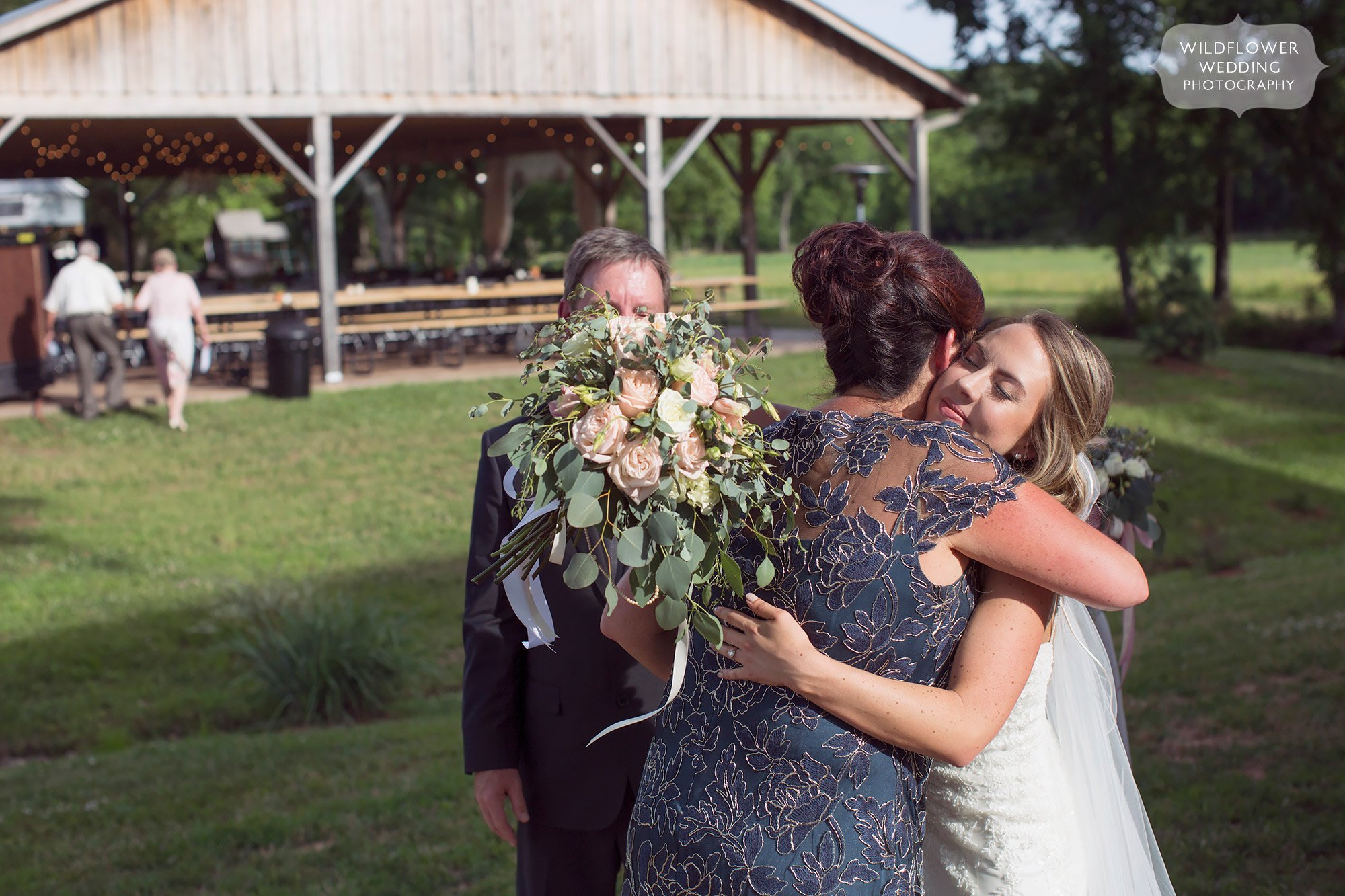Emotional photo of the bride and her mom hugging after the barn ceremony.