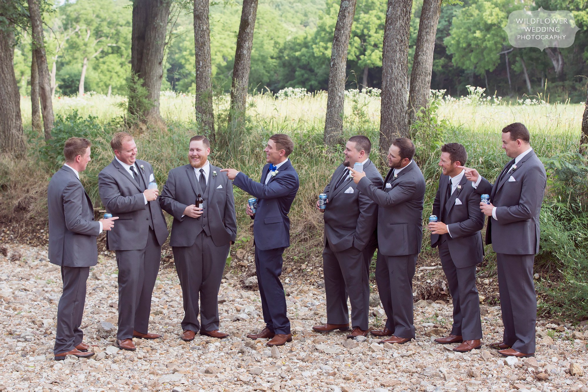 Funny photo of the groomsmen in the creek at this country wedding in MO.