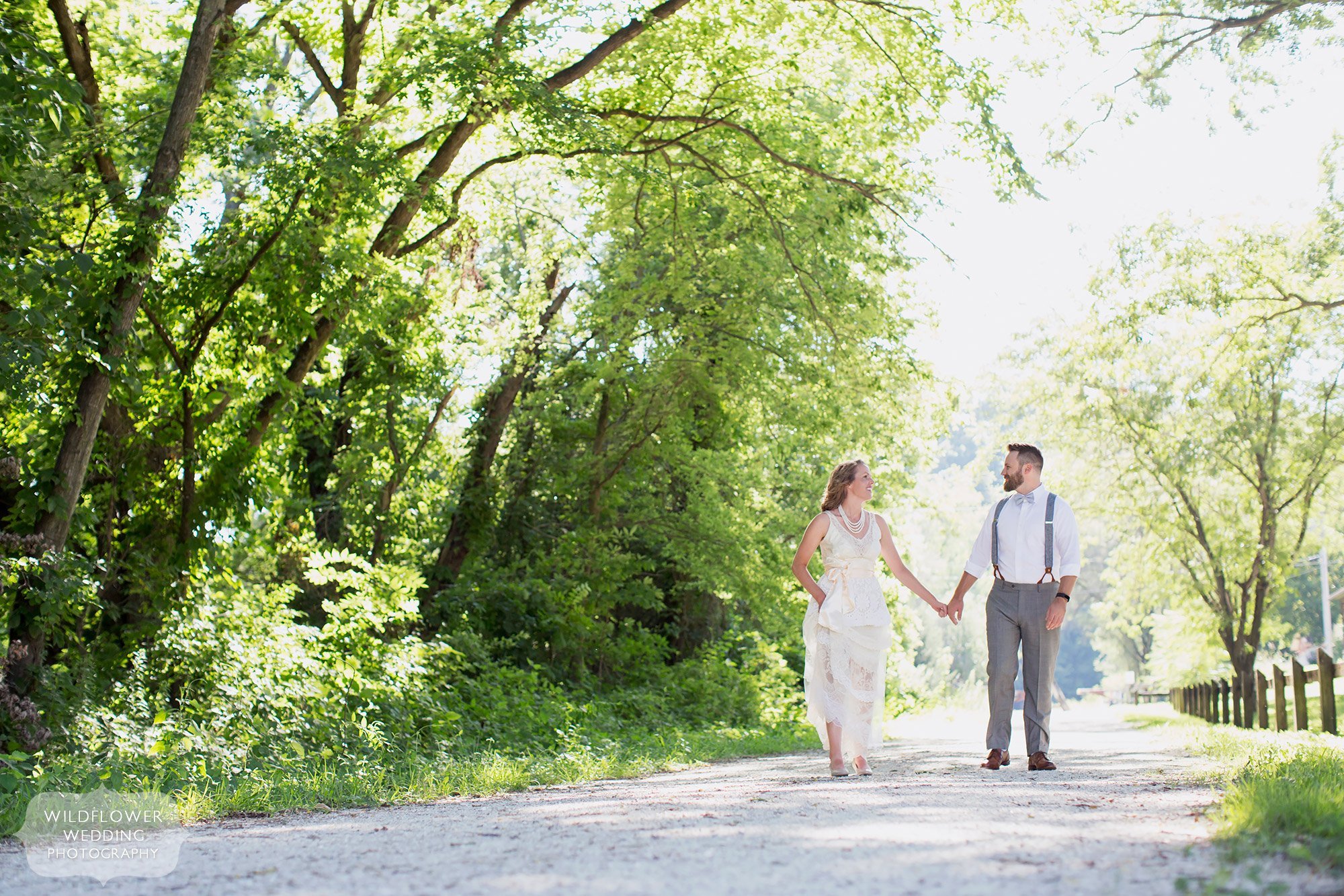 The bride and groom walk along the Katy Trail before their Rocheport winery wedding at Les Bourgeois in the summer.