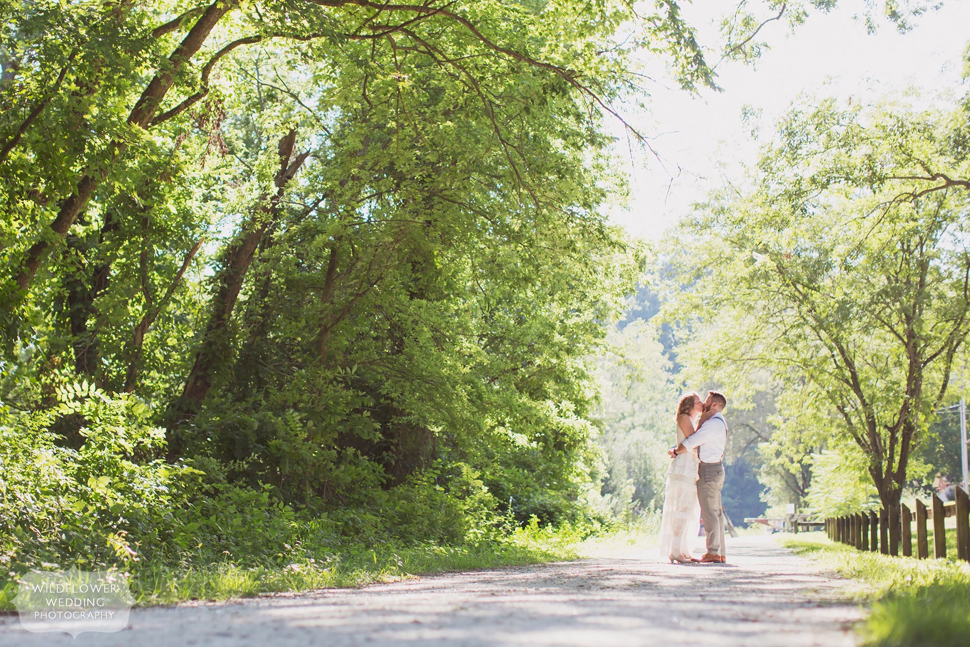 Anthropologie style wedding photography of the bride and groom kissing on the Katy Trail before their Les Bourgeois Winery wedding in Rocheport.