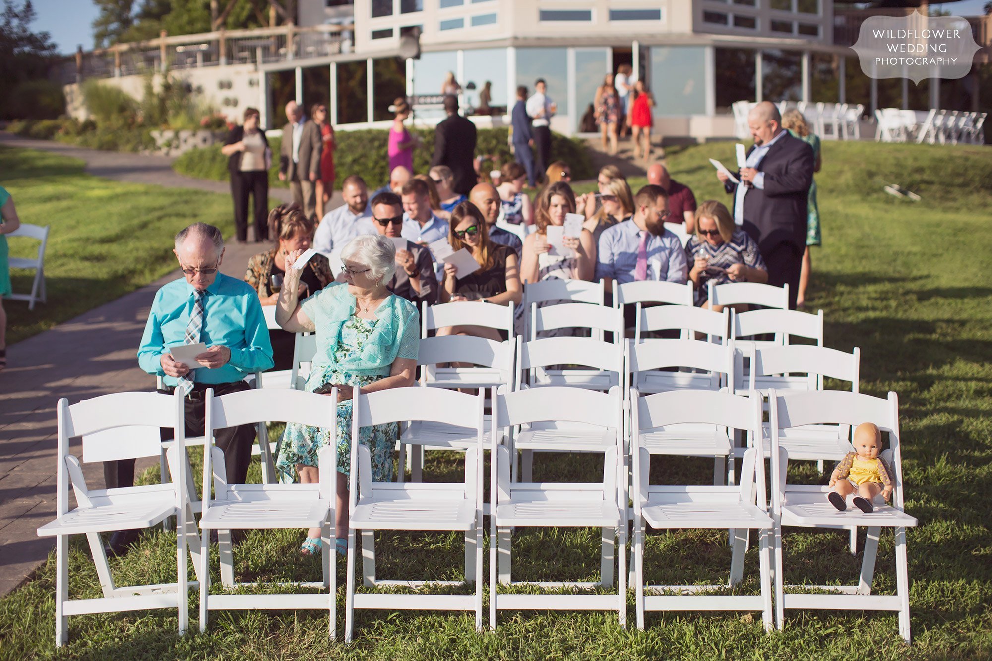 funny wedding ceremony scene with a baby doll in a chair at outdoor ceremony in rocheport