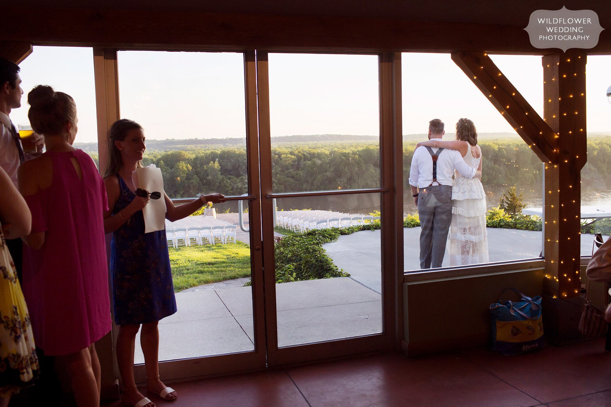 bride and groom look out toward missouri river on the les bourgeois winery patio