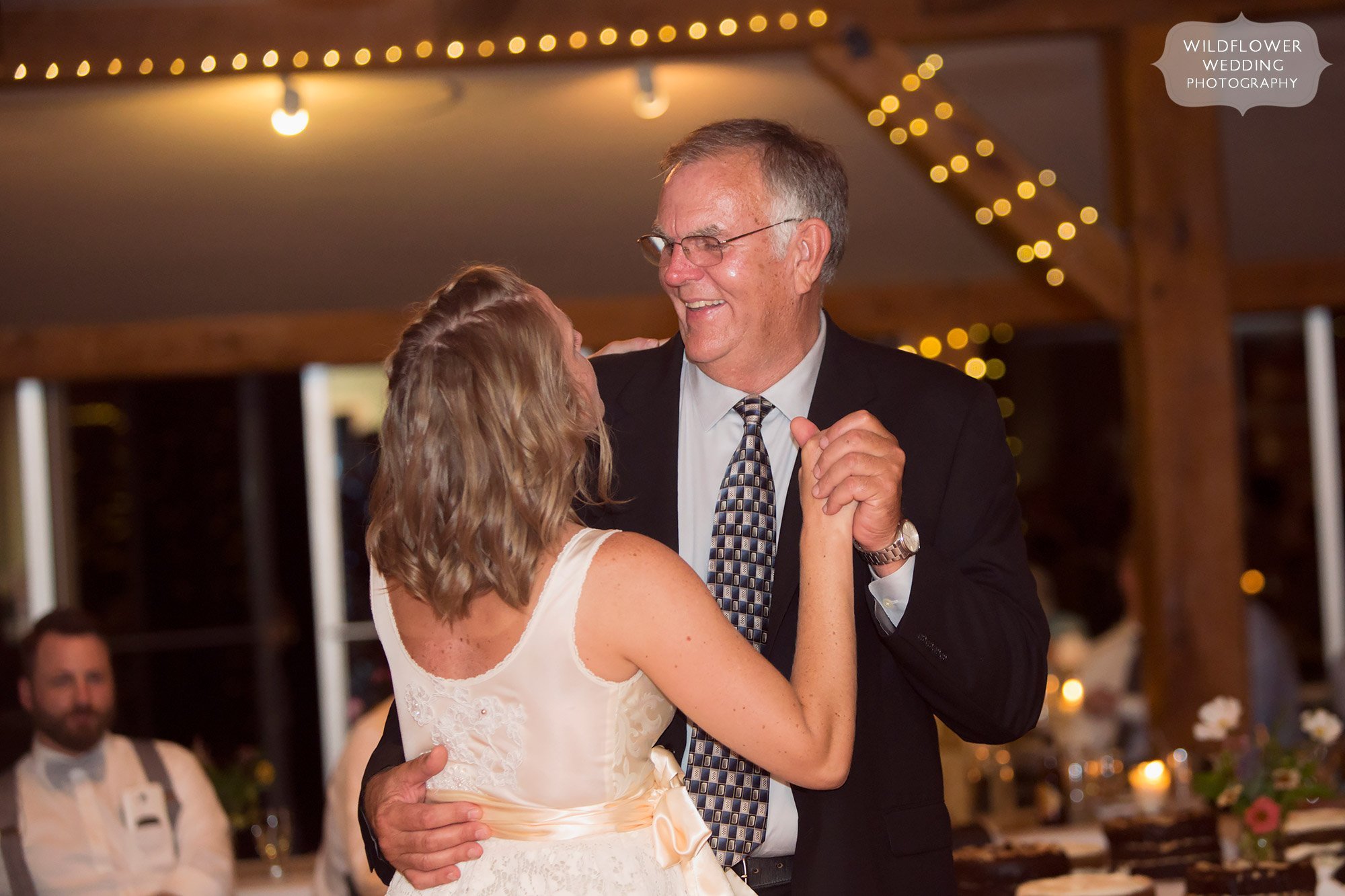 dad looks down at his daughter during their dance at missouri wedding winery