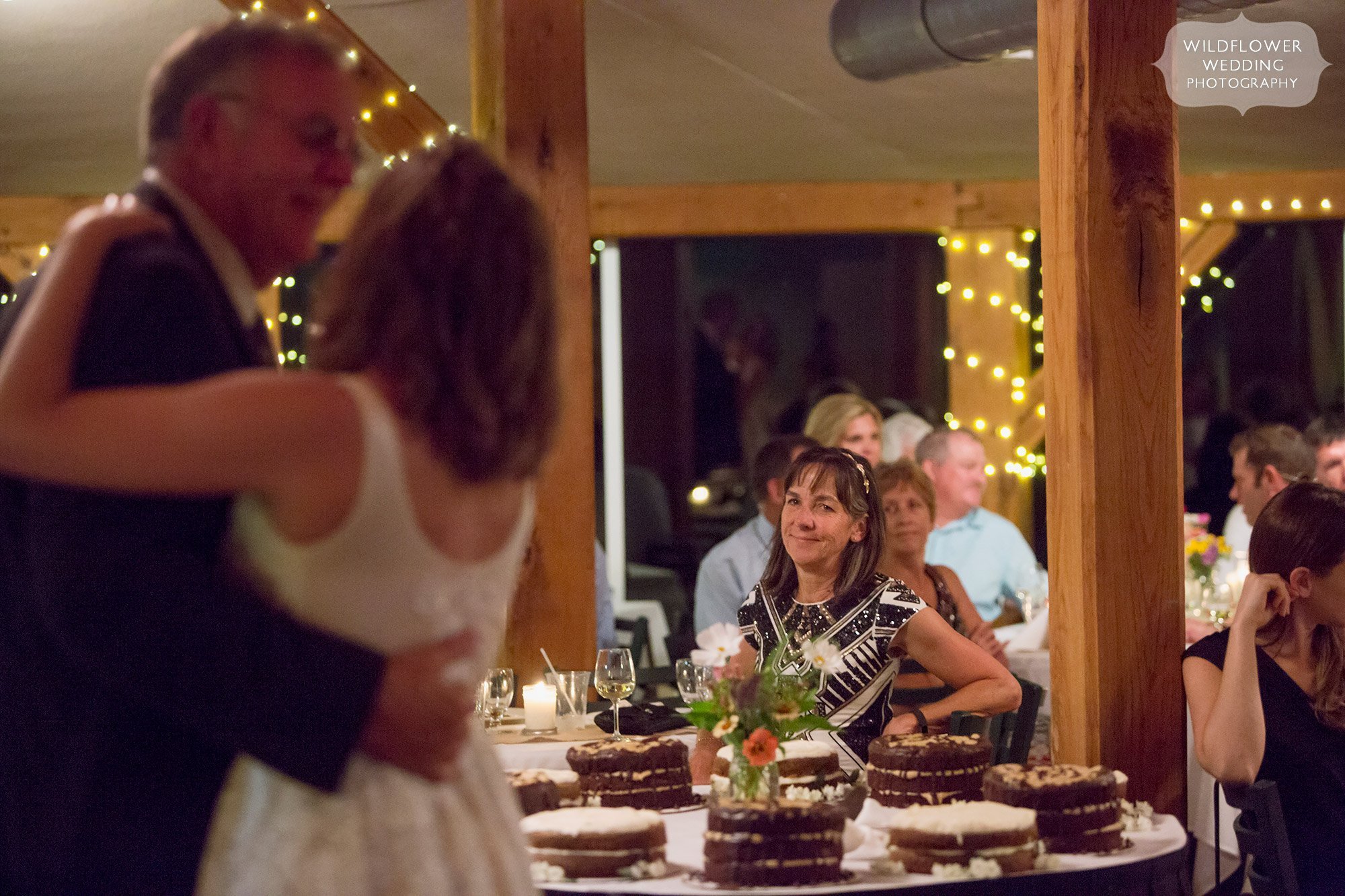 great candid moment of mother of the bride watching her daughter dance with her dad 
