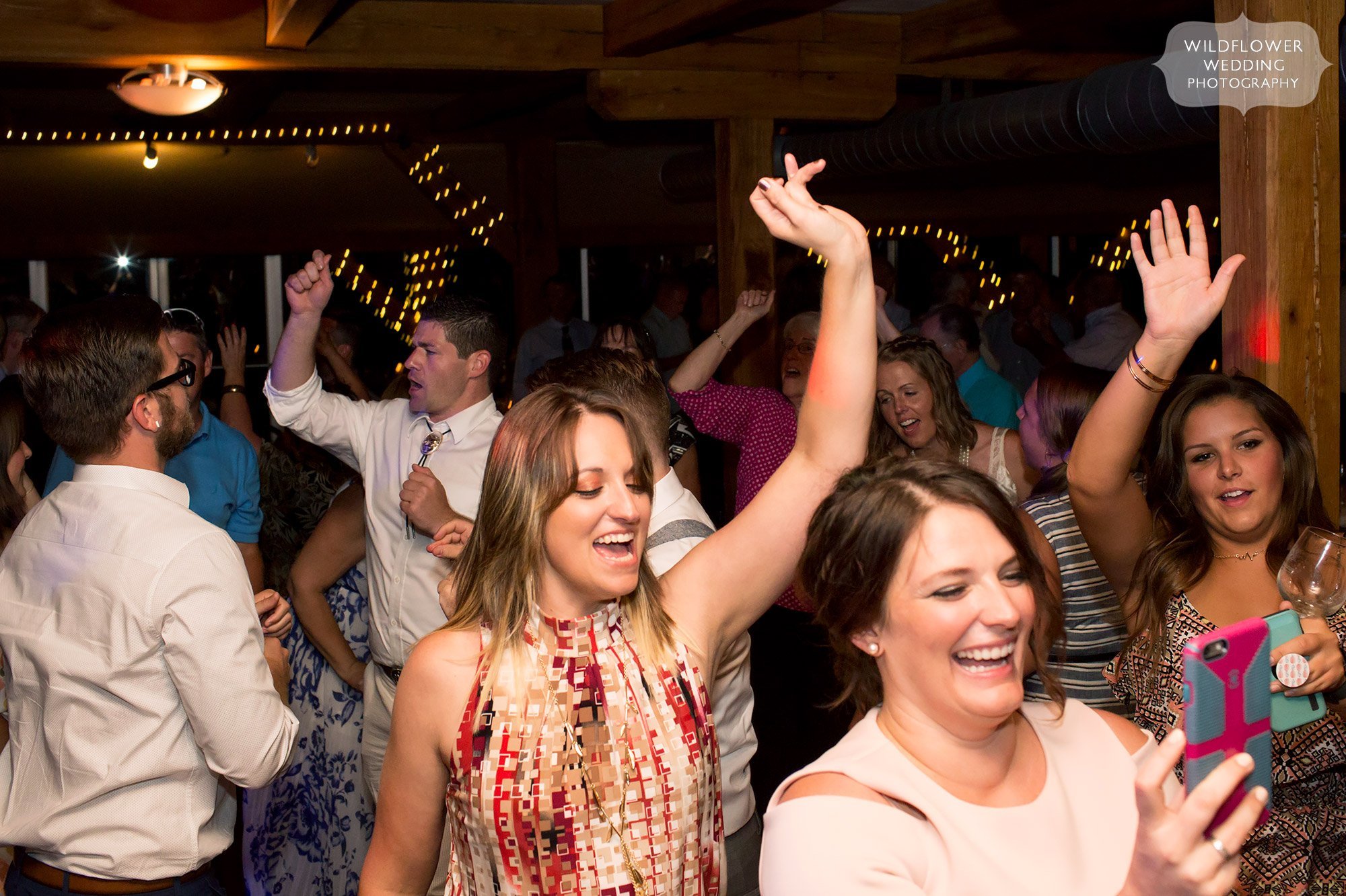 guests put hands in the air while dancing at les bourgeois wedding reception