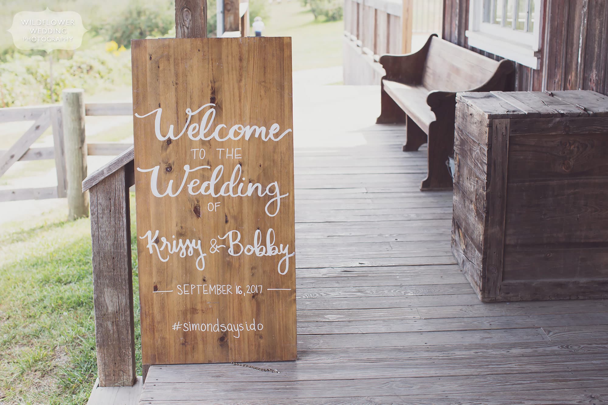 A wood plank sign with calligraphy script font at this barn wedding in MO.