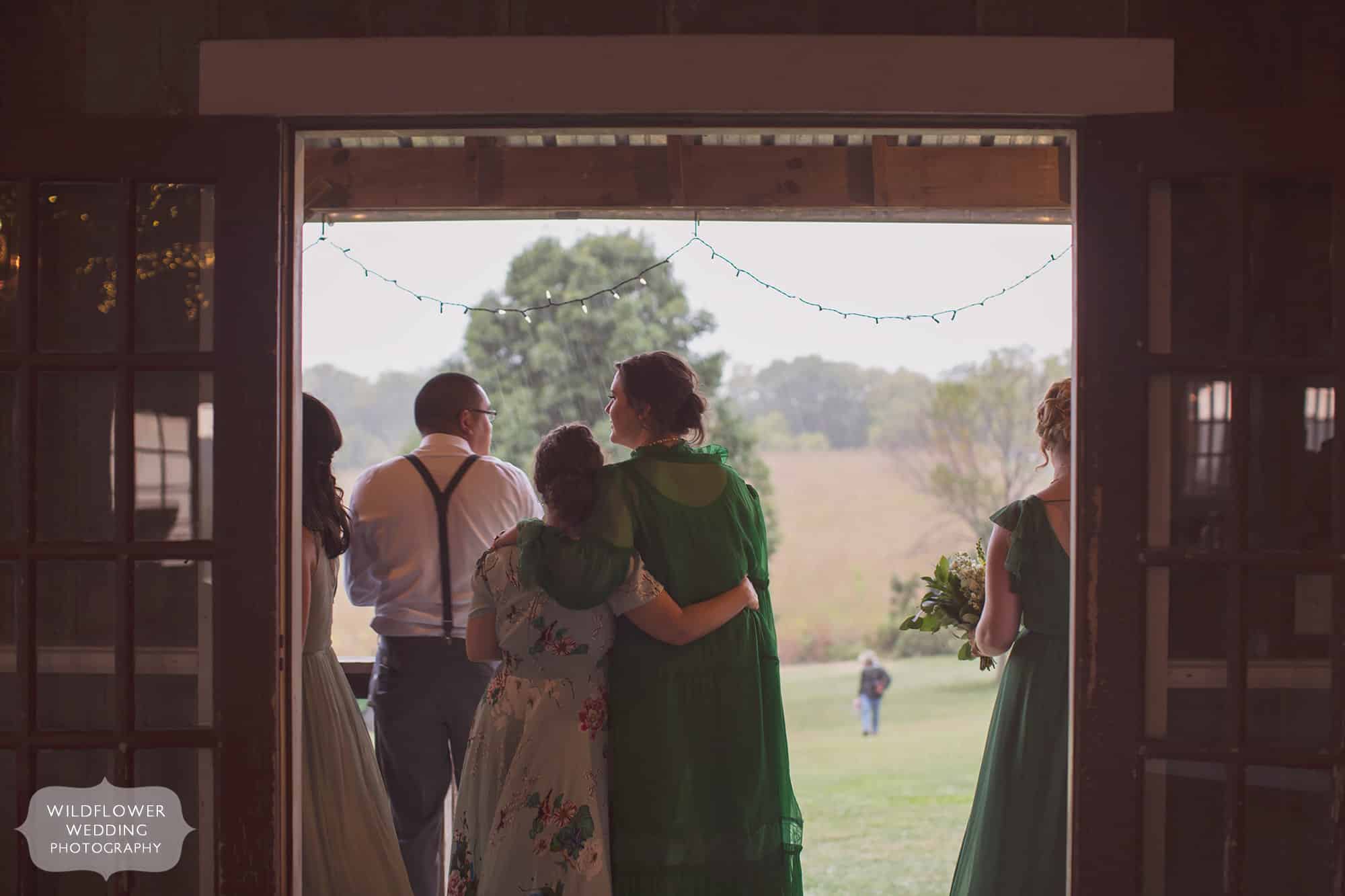 Bridesmaids huddle on the porch during a wedding in Weston, MO.