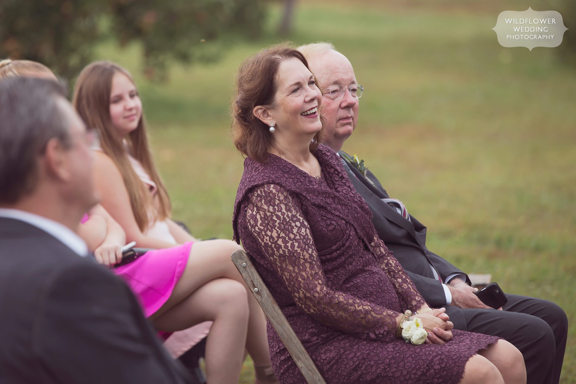 The mother of the groom watches the outdoor ceremony in Weston, MO.