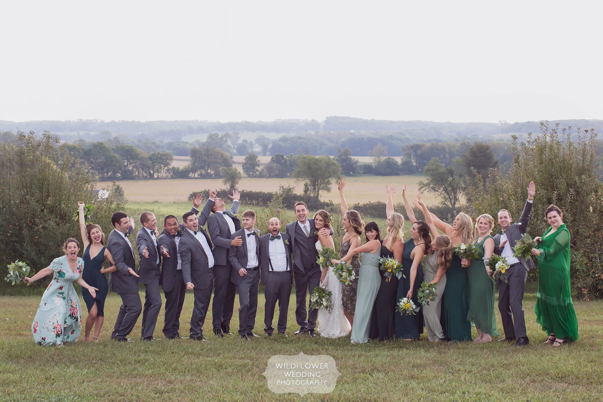 Huge wedding party with high energy pose at the Weston Red Barn Farm.