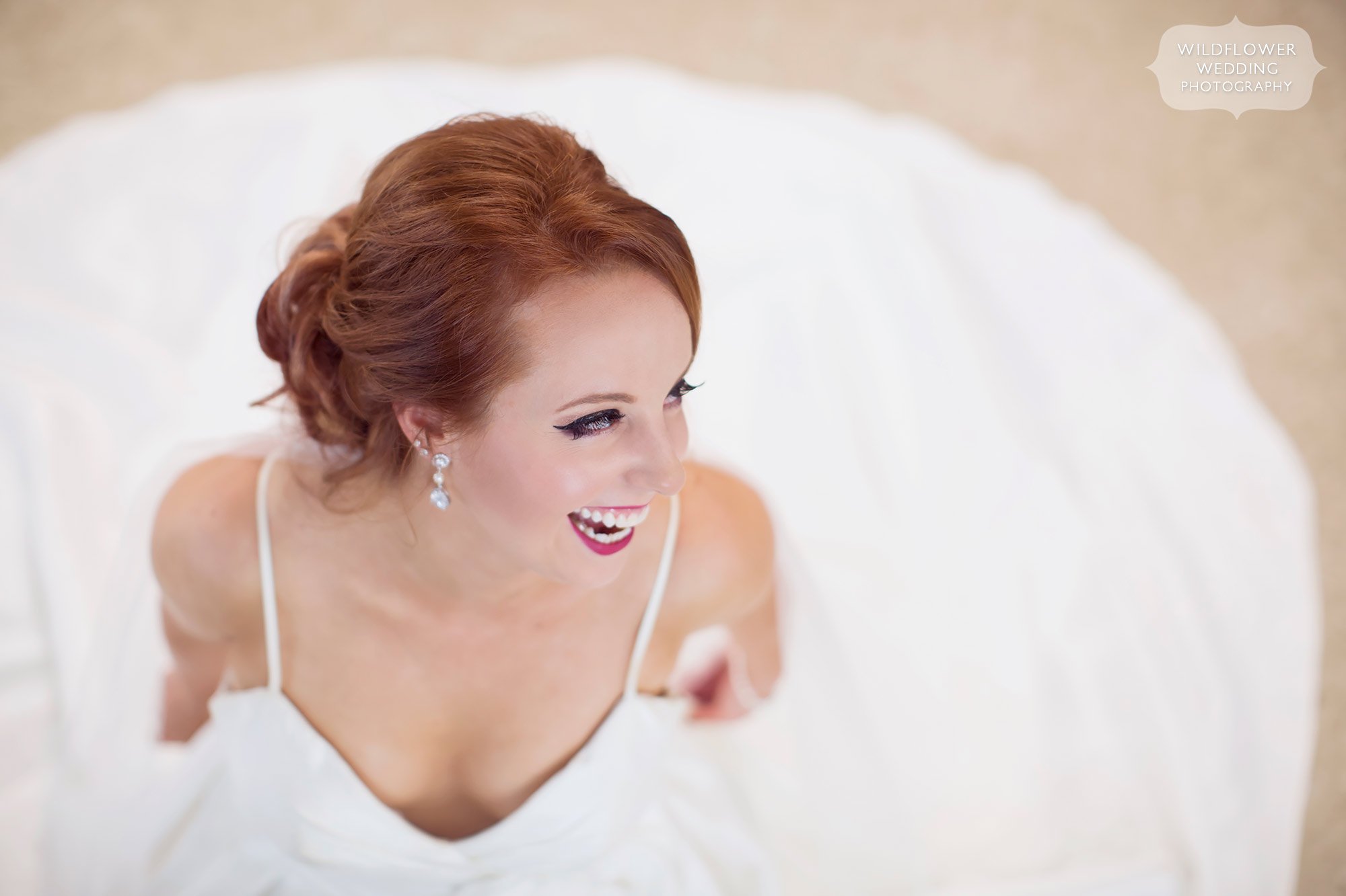 Beautiful portrait of bride laughing surrounded by dress at her Jefferson City, MO wedding.