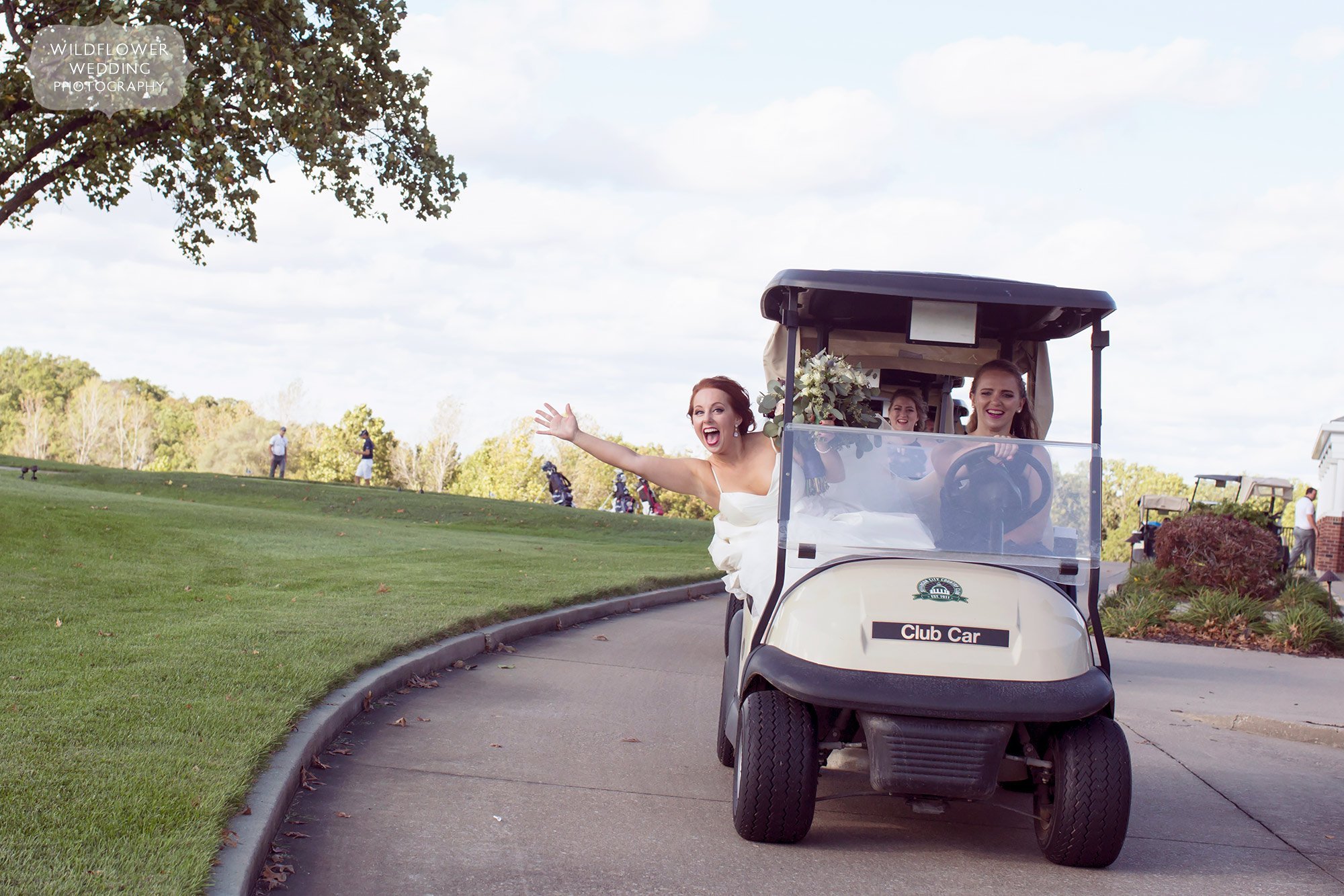 The bride smiling while riding in a golf cart at the Jefferson City Country Club.