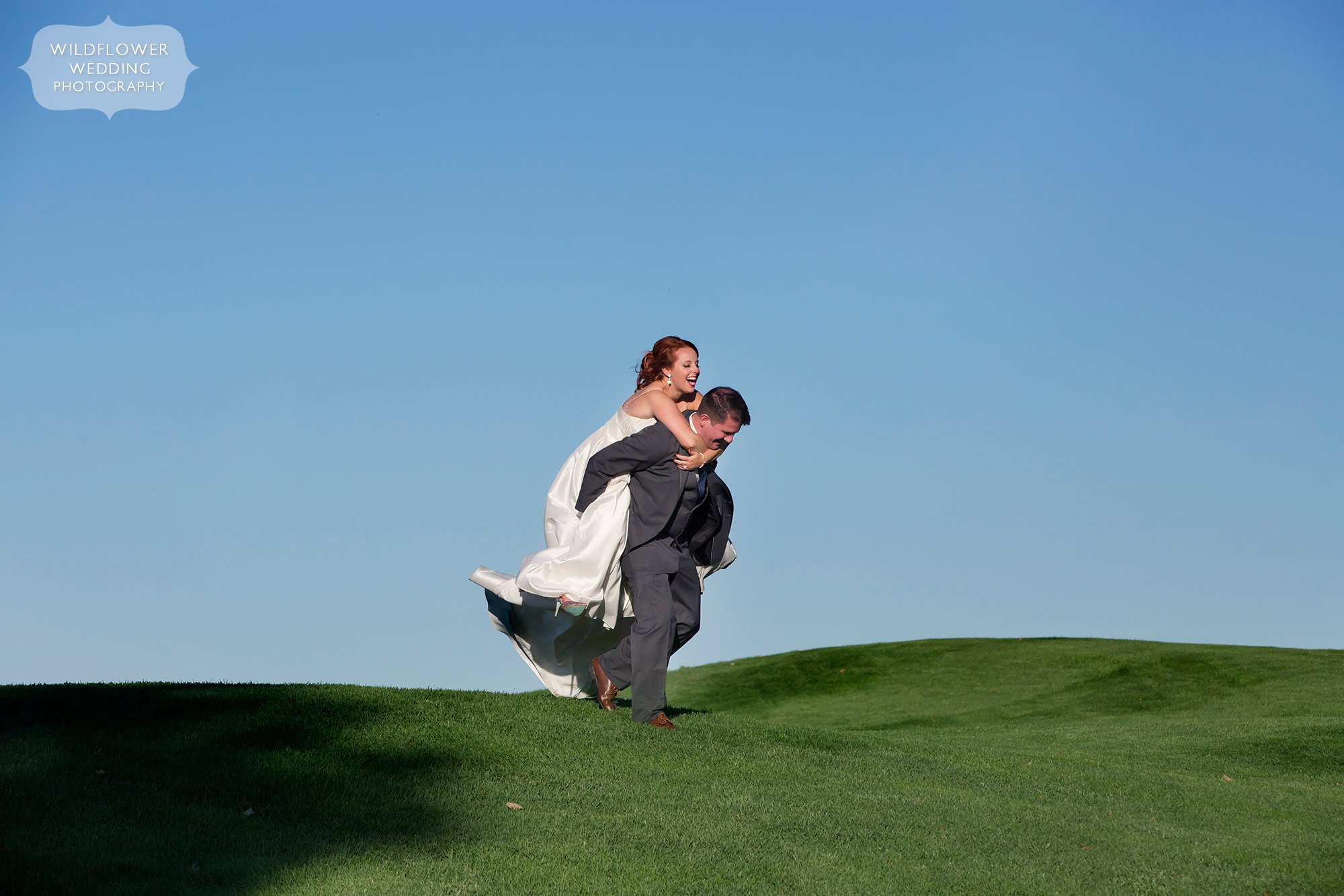 The groom gives the bride a piggyback ride at the Jeff City Country Club.