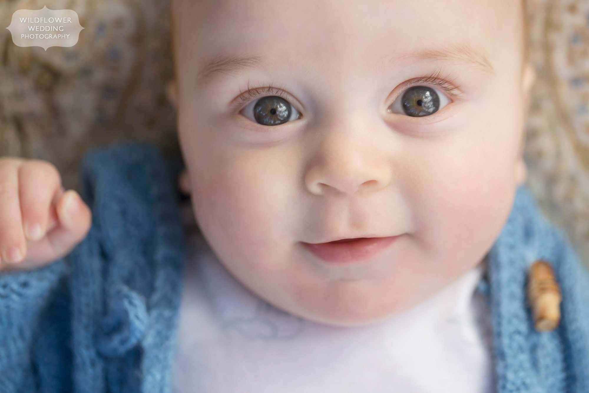 Close up of baby's face in blue sweater for natural family photography session in KC.
