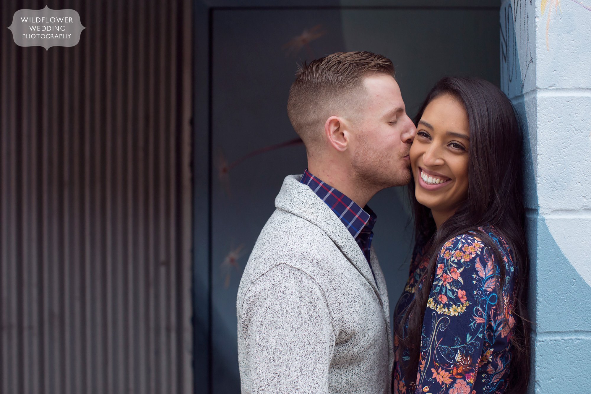 Girlfriend is kissed on the cheek during an engagement session in downtown Columbia, MO.