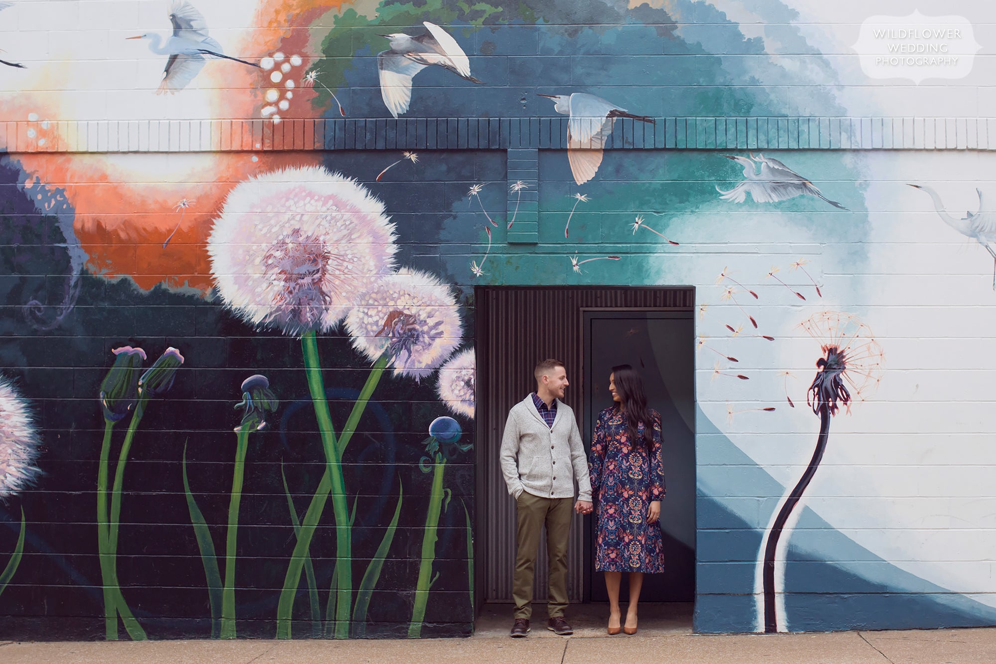 Couple surrounded by mural during downtown Columbia engagement photography shoot.