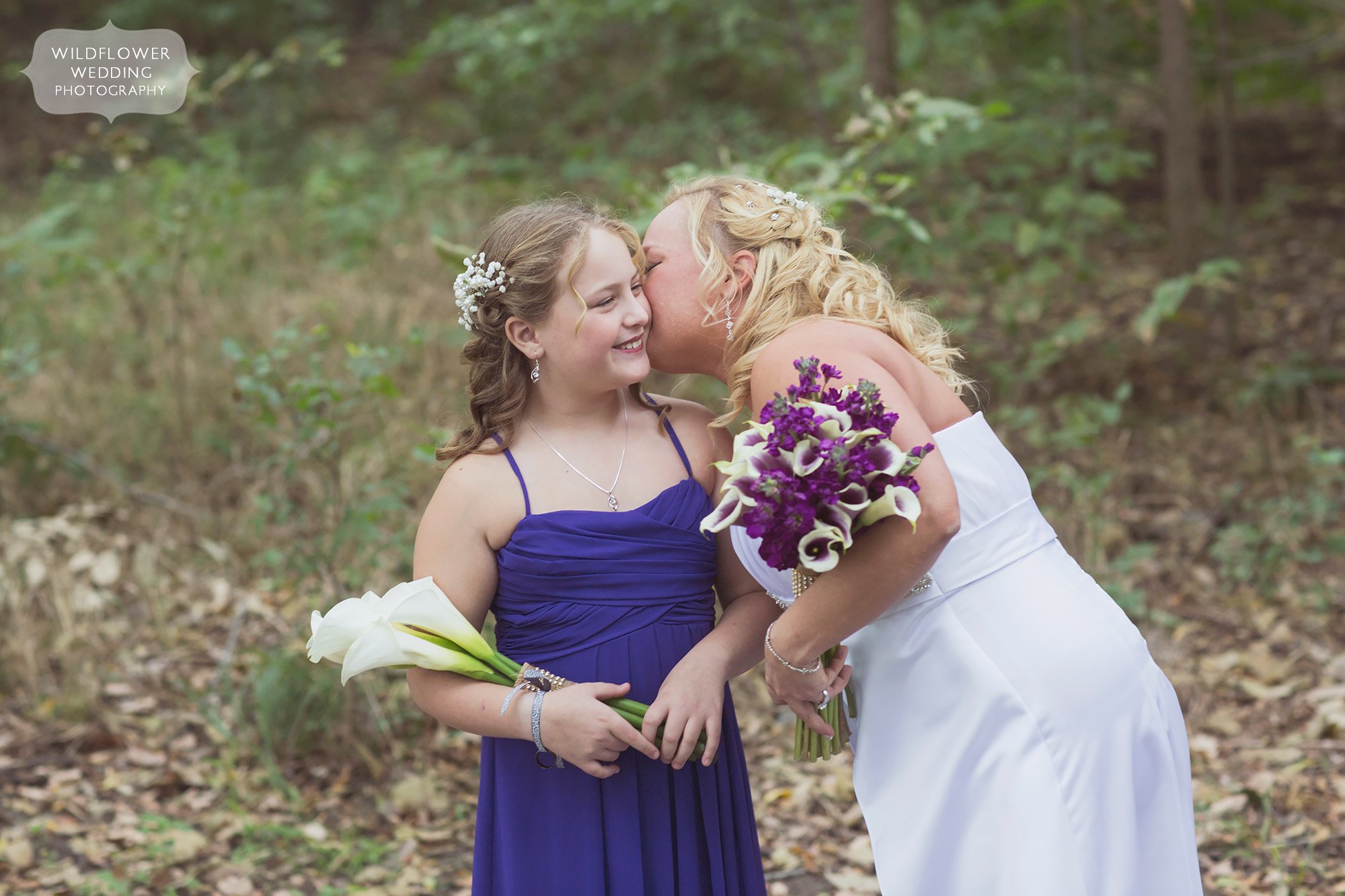 The bride kissing her daughter on the cheek at this KS barn wedding venue.