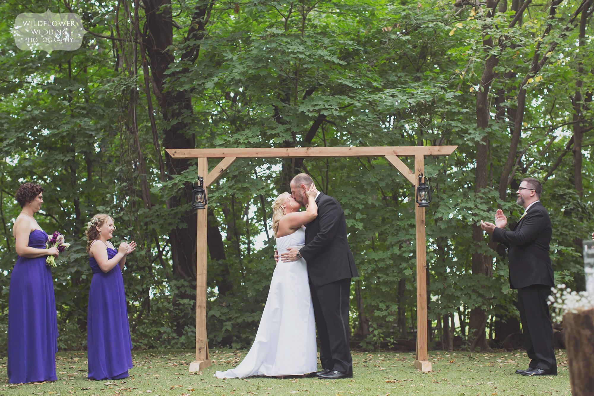 The bride and groom kiss during their outdoor ceremony at Schwinn Barn.
