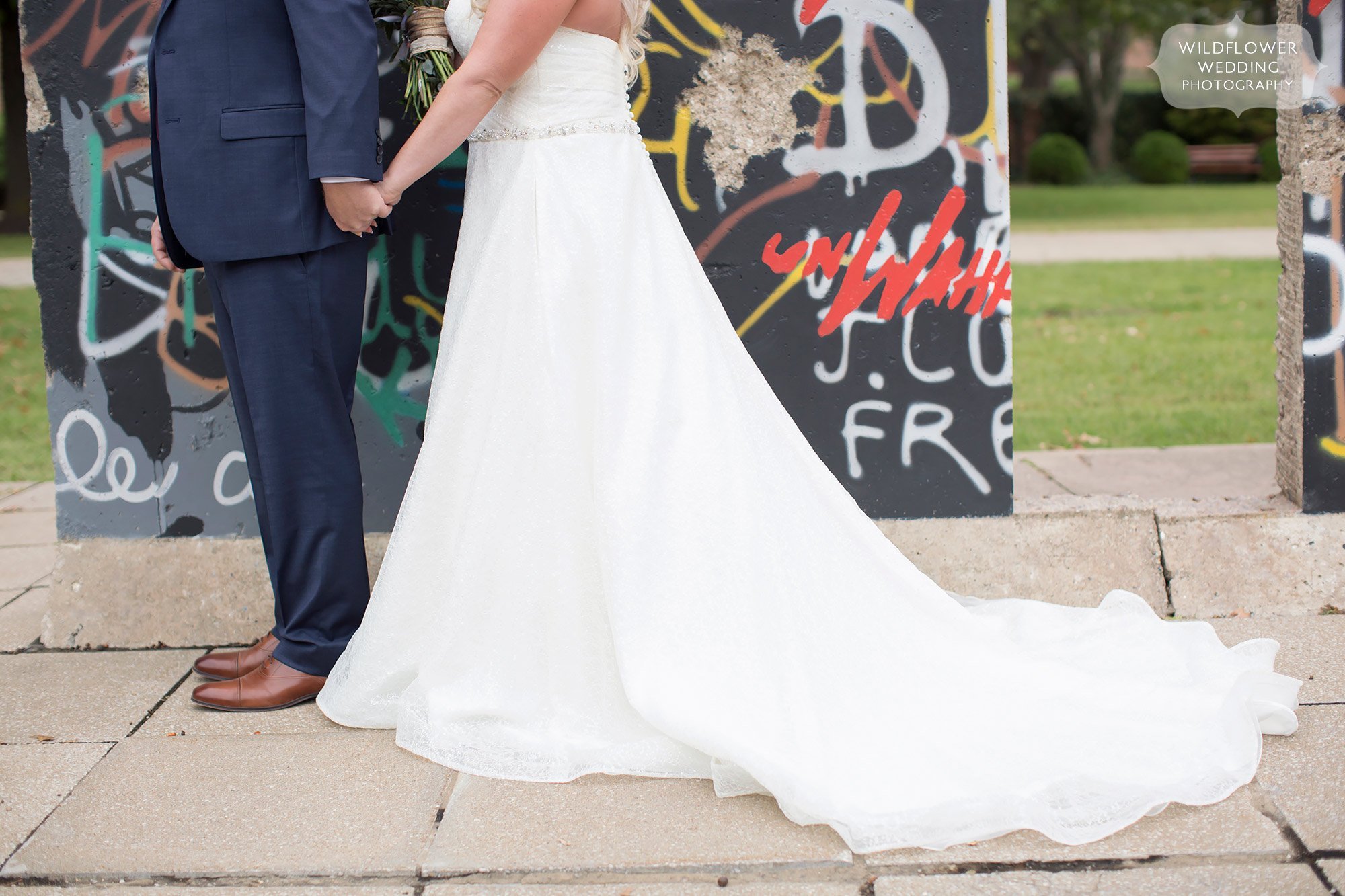 The bride and groom in front of a piece of the Berlin Wall on the Westminster campus in Fulton, MO.