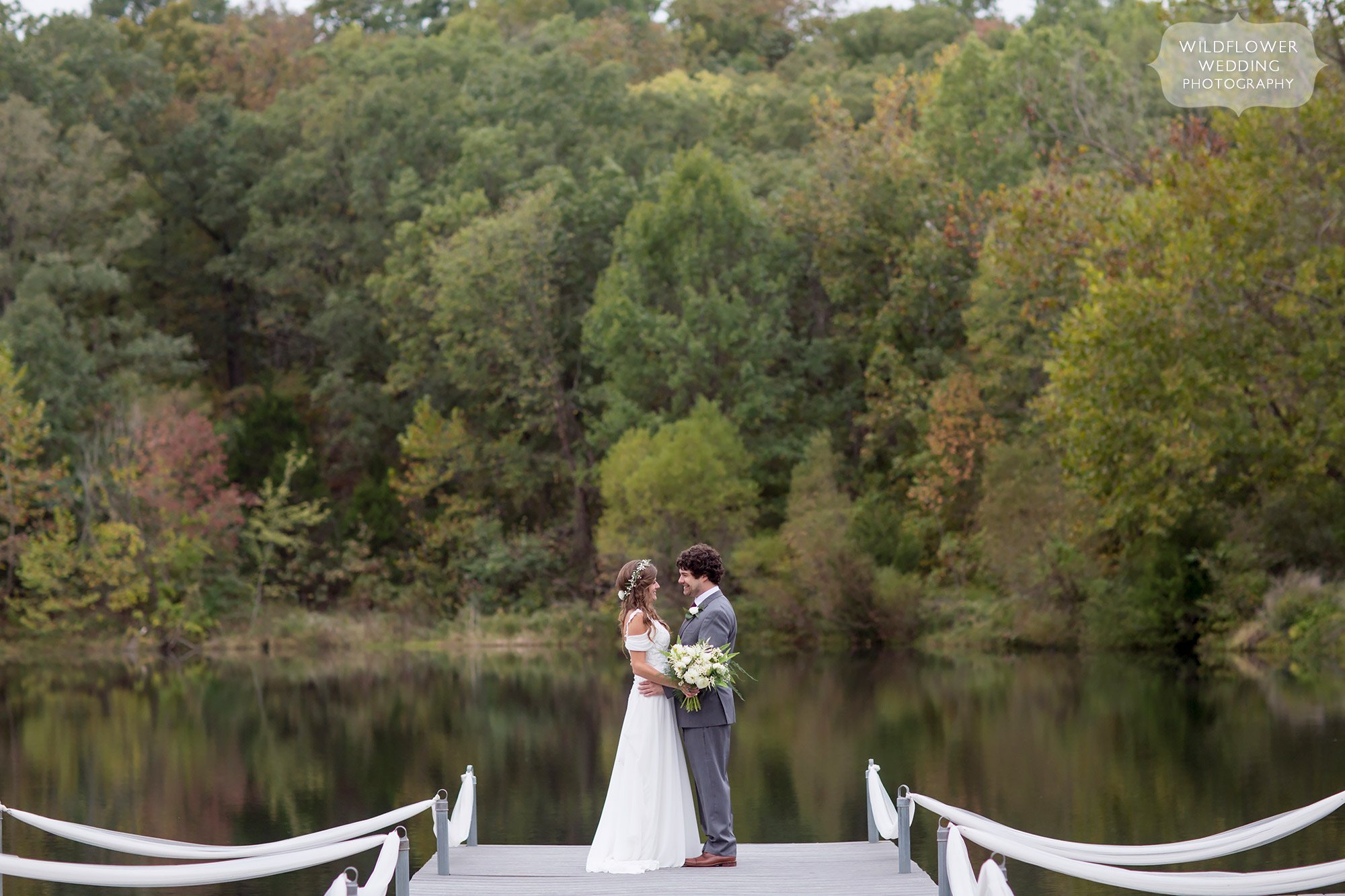 The bride and groom pose on the dock at their lakeside wedding in Hermann, MO at Little Piney.
