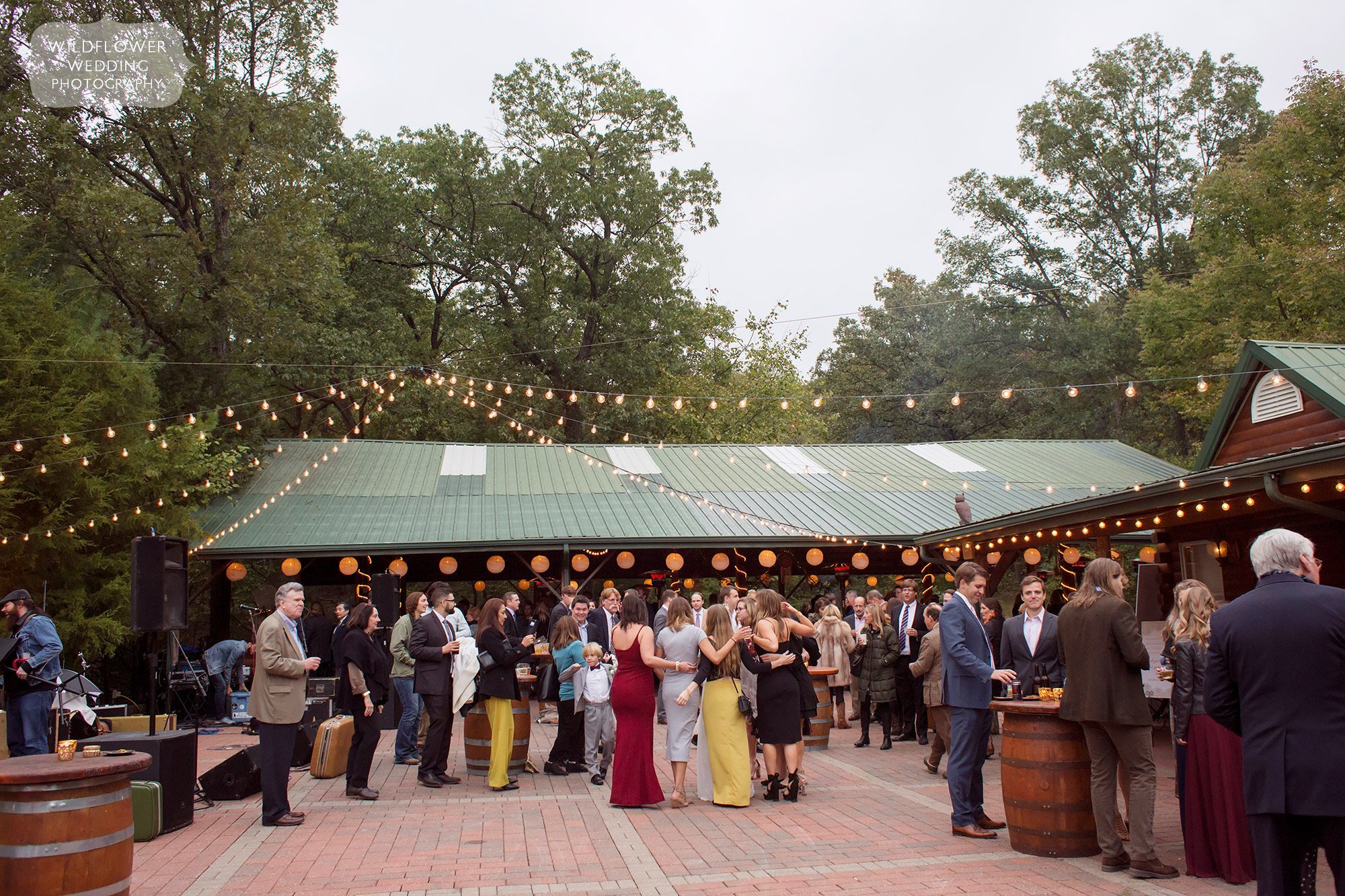 Guests enjoy an outdoor cocktail hour before entering pavilion for reception at Little Piney Lodge.