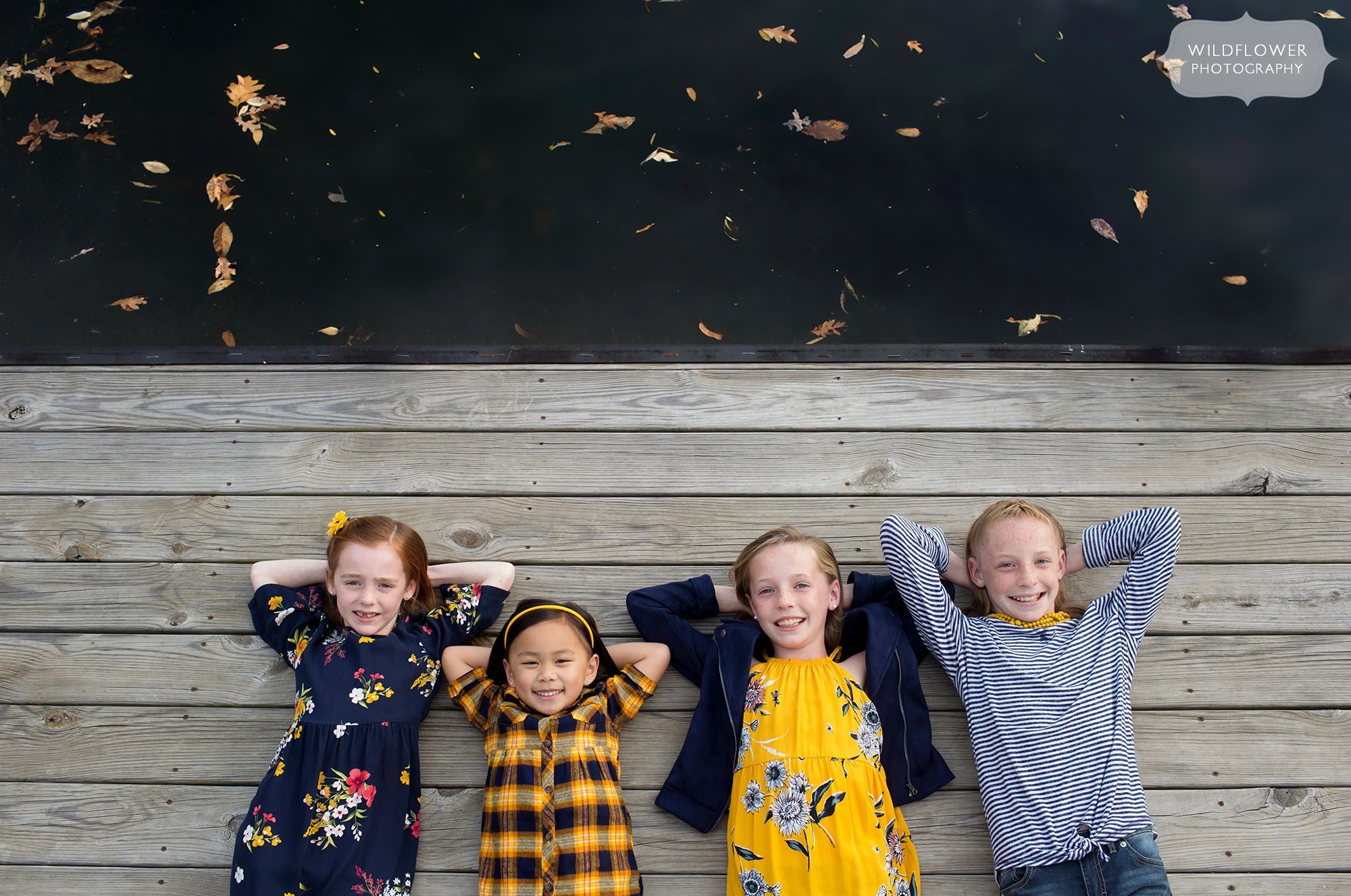 Kids lay on a dock in Columbia, MO during this fall family photo session.