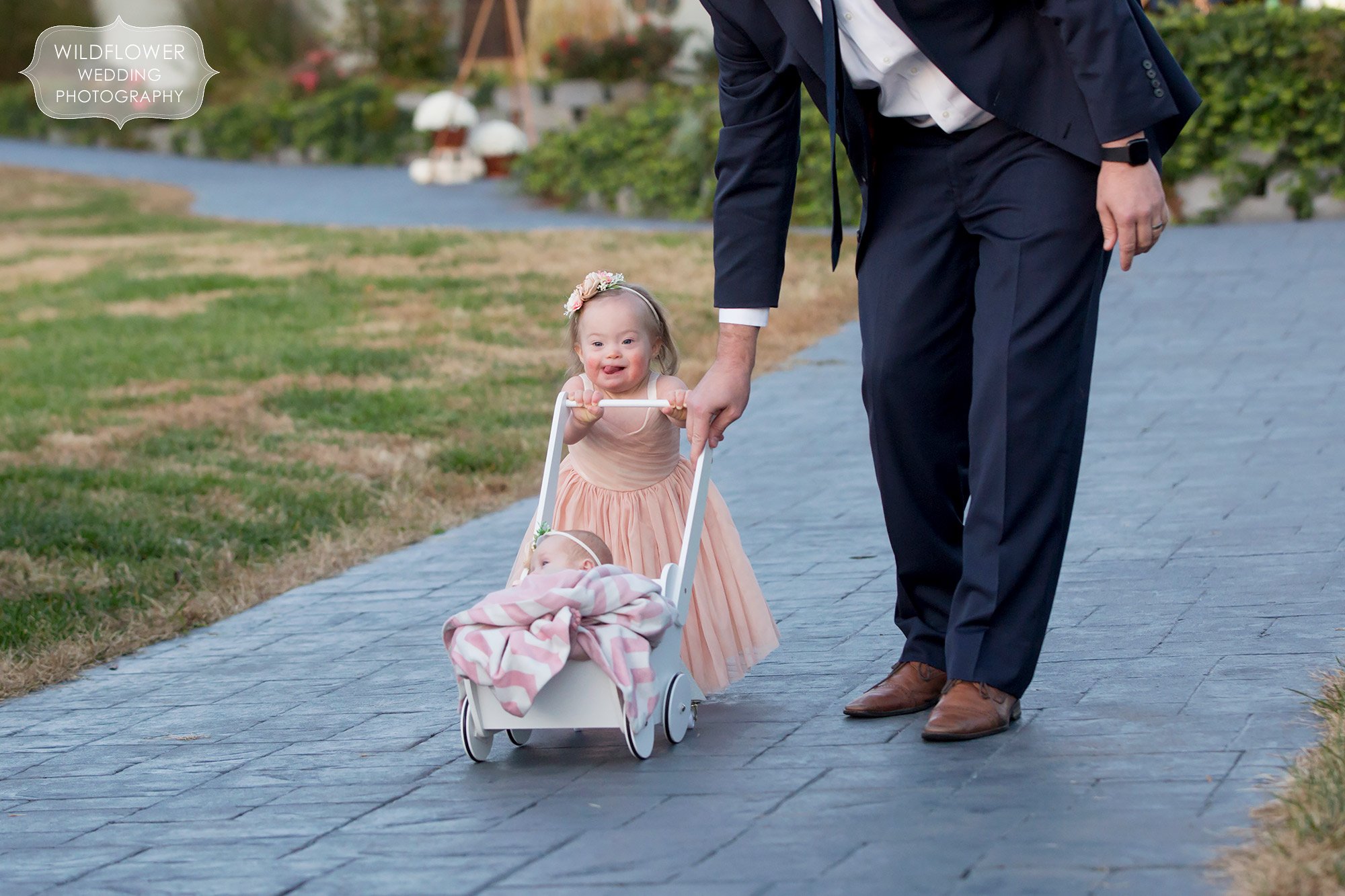 This sweet toddler flower girls is helped down the aisle by her dad at Les Bourgeois.