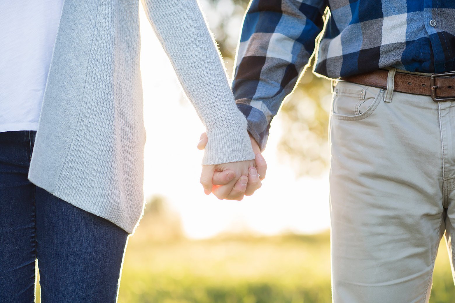 Couple holds hands during this mid-MO country engagement session in Boonville during sunset.